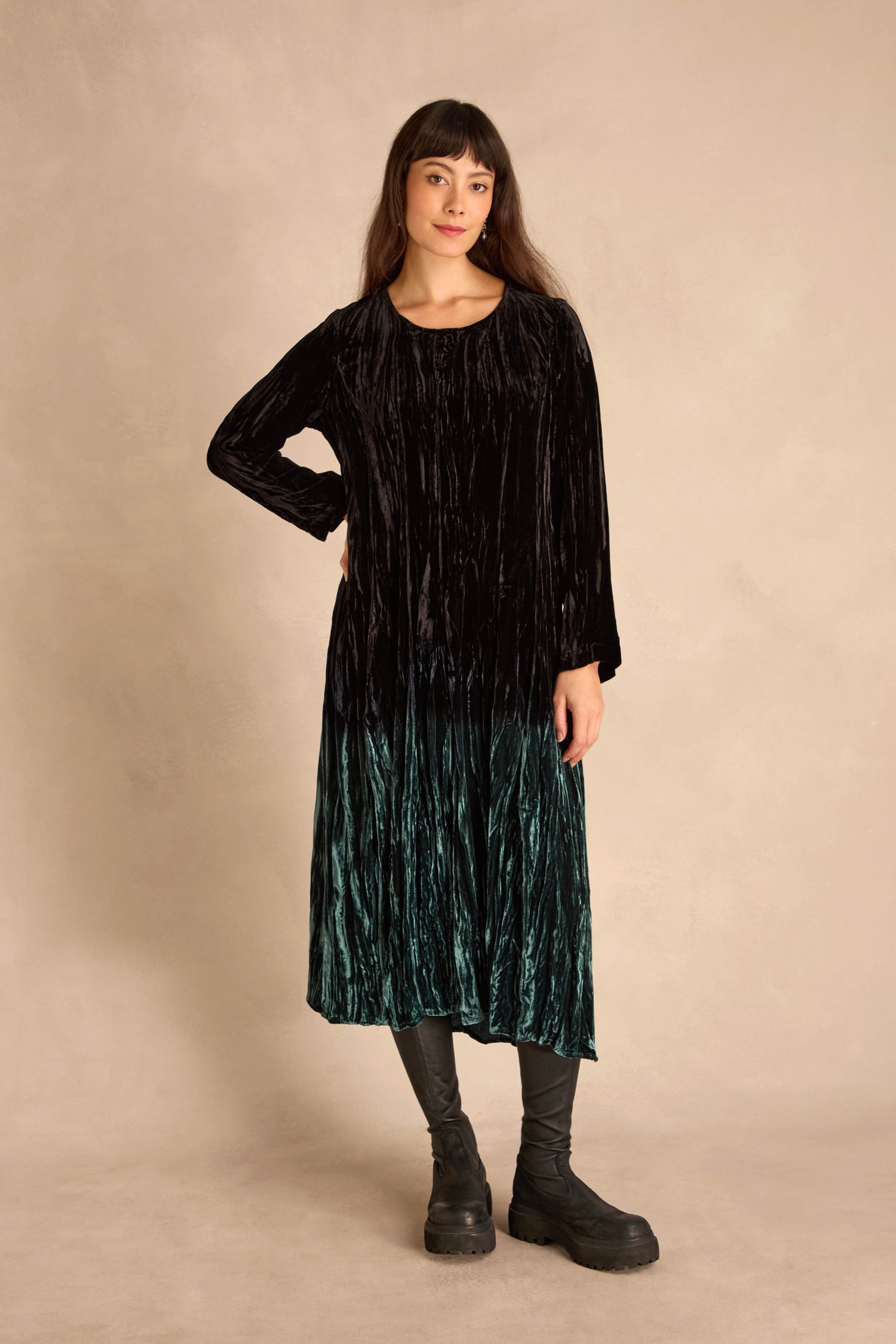 Woman standing against a beige backdrop, wearing the Silk Velvet Ombre Bubble Dress with black tights and chunky black boots.