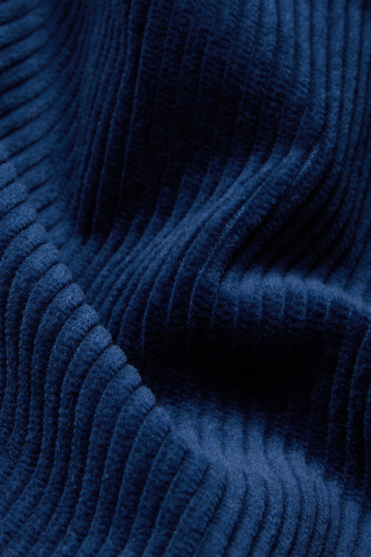 Close-up of the Marine Jumbo Cord Bubble Trousers, highlighting the blue pure cotton corduroy fabric with prominent vertical ridges and a soft texture, featuring visible folds and shadows.