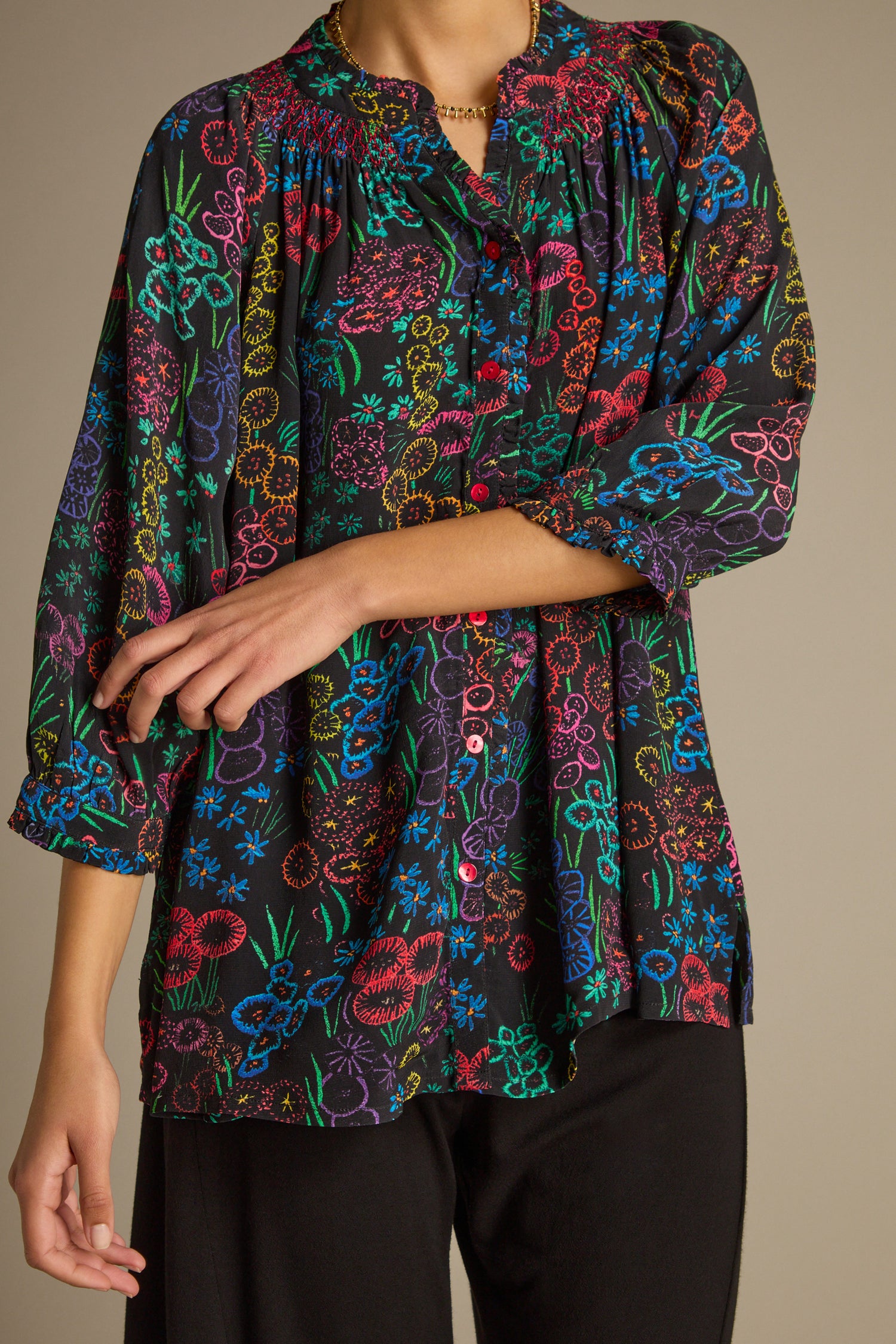A person wearing a lively Floral Embroidery Print Shirt paired with sleek black pants, standing confidently with one hand on their hip.