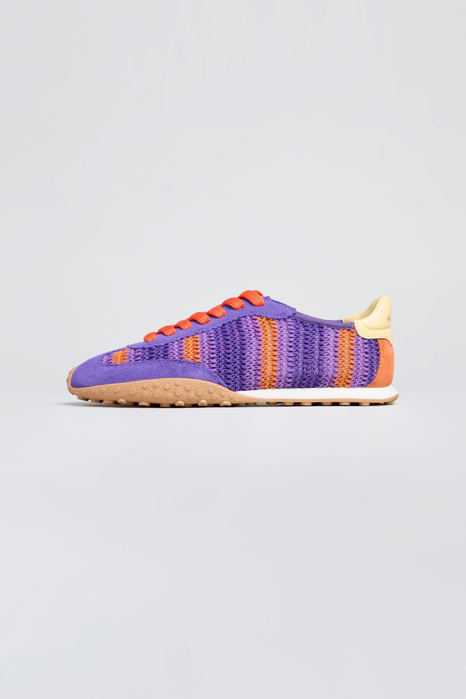 The Bridge Woven Purple Crochet Trainers feature a purple and orange woven upper, orange laces, beige heel tab, and a textured cushioned sole—ideal for fans of crochet-style sneakers.