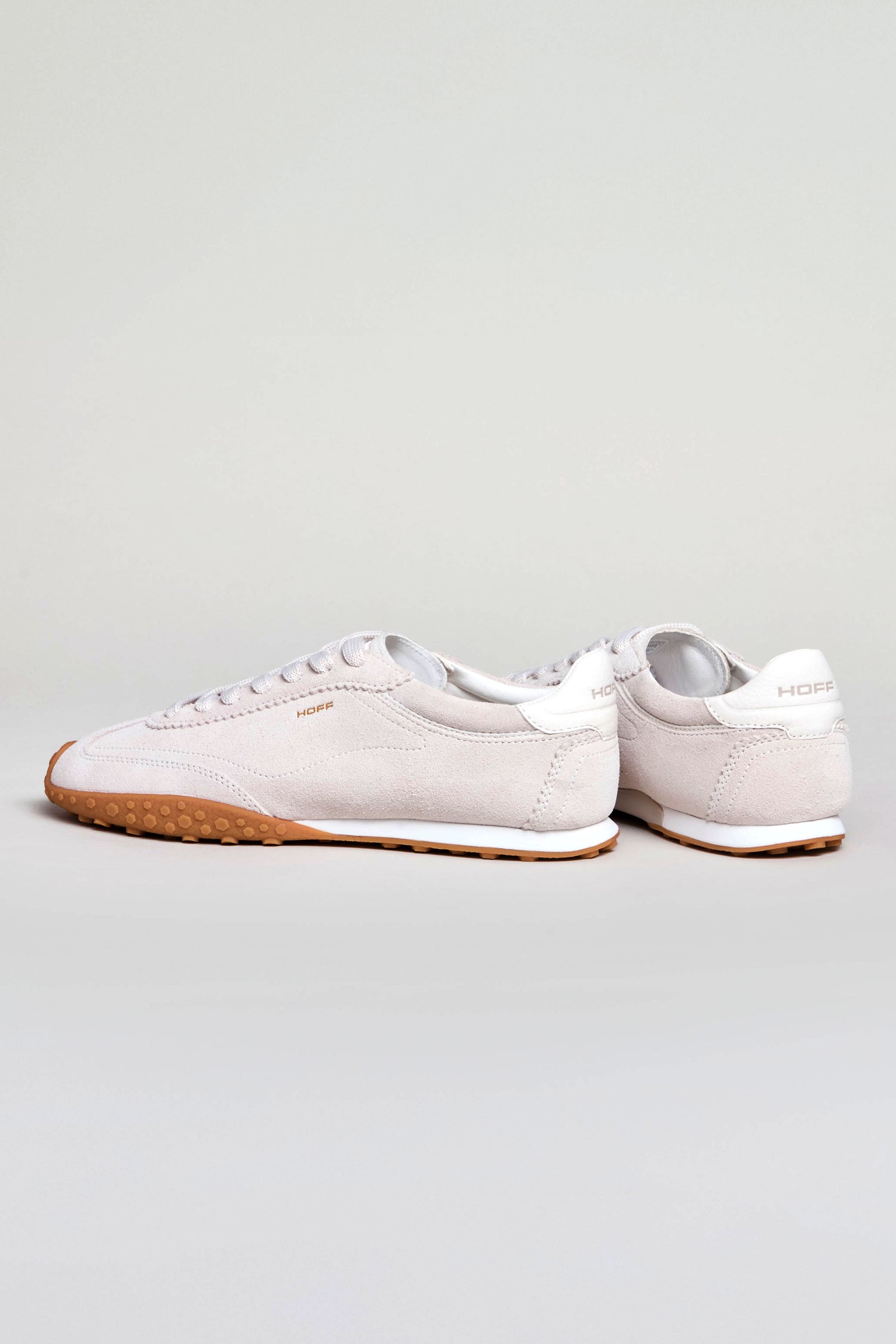 A pair of Bridge Suede Trainers in white with light brown soles, featuring a retro running style, displayed on a plain light gray background.