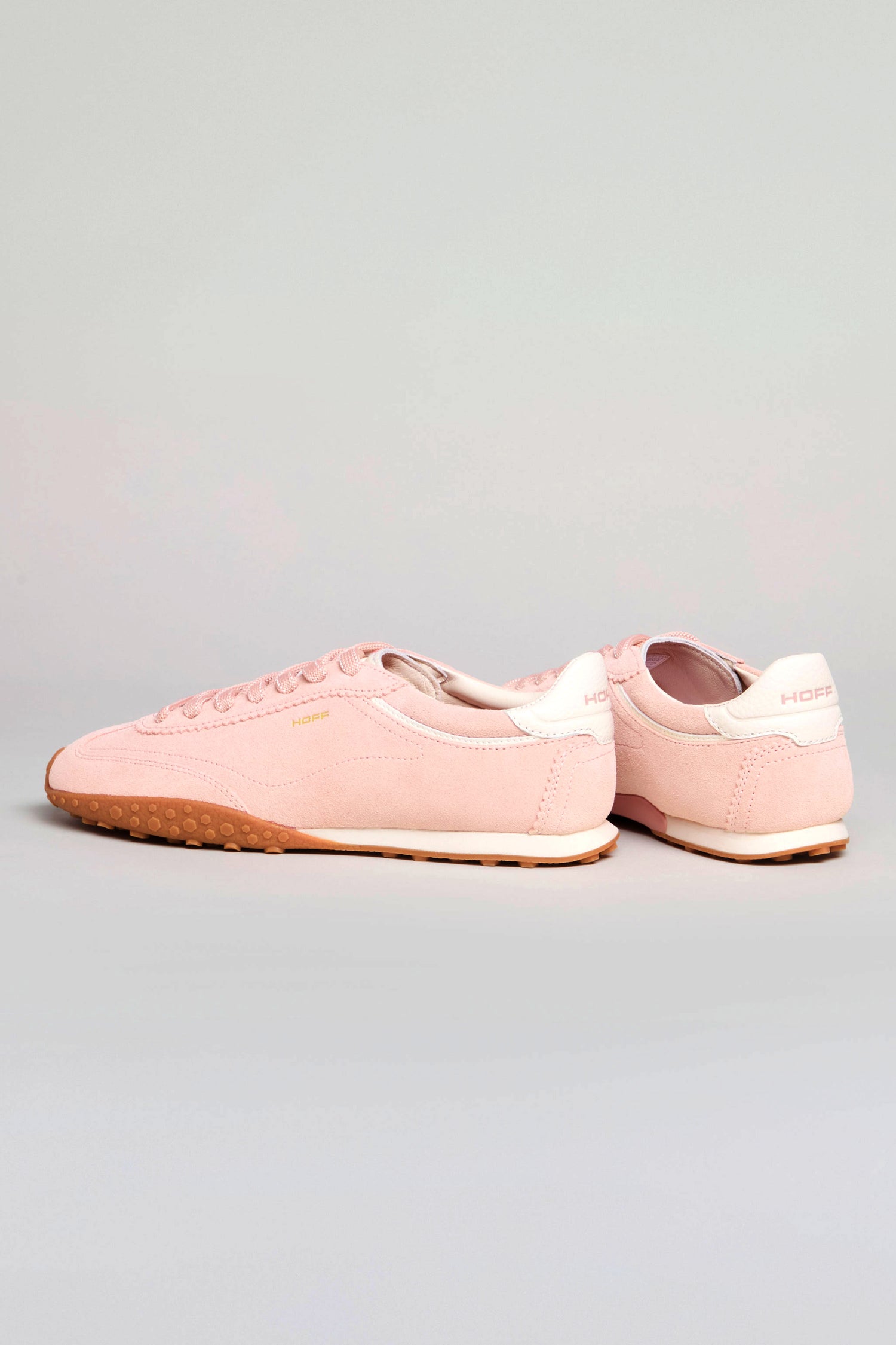 The Bridge Rose Suede Trainers feature light pink suede, white heel accents, and gum soles, styled on a neutral background for a retro running-inspired look.