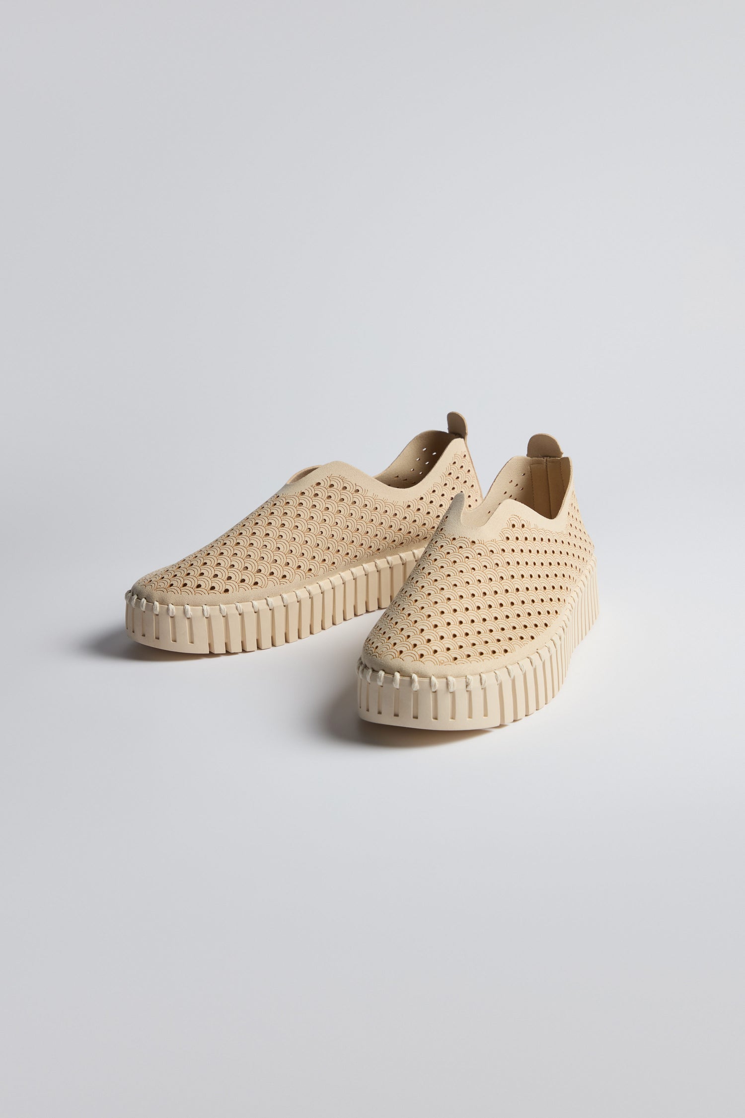 A pair of beige Tulip Slip On Shoes by Ilse Jacobsen, featuring perforated uppers and thick, textured platform soles, are placed on a plain light background.