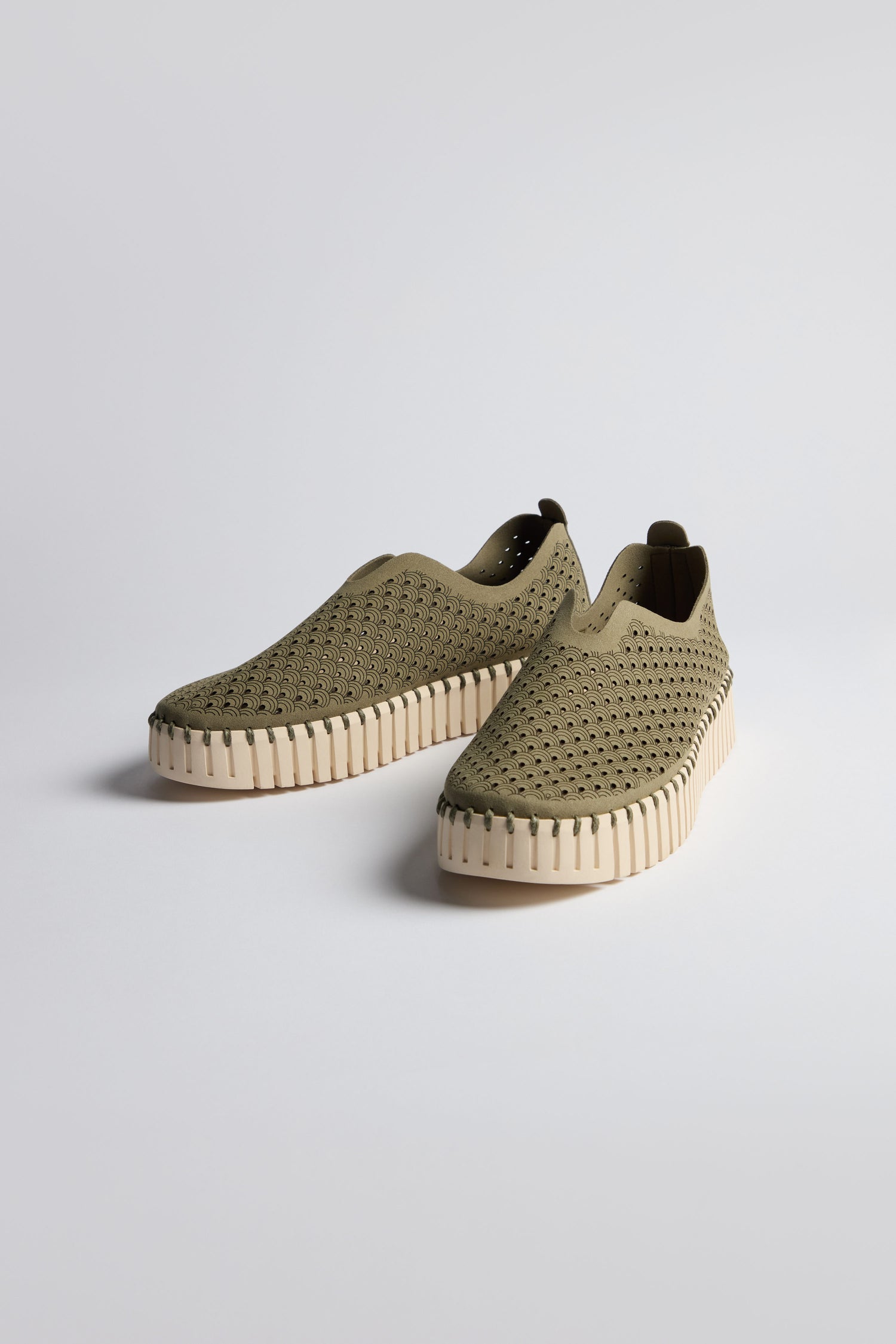 A pair of Khaki Tulip Platform Slip On Shoes featuring perforated uppers and thick, cream-colored ridged soles, displayed on a plain light background.