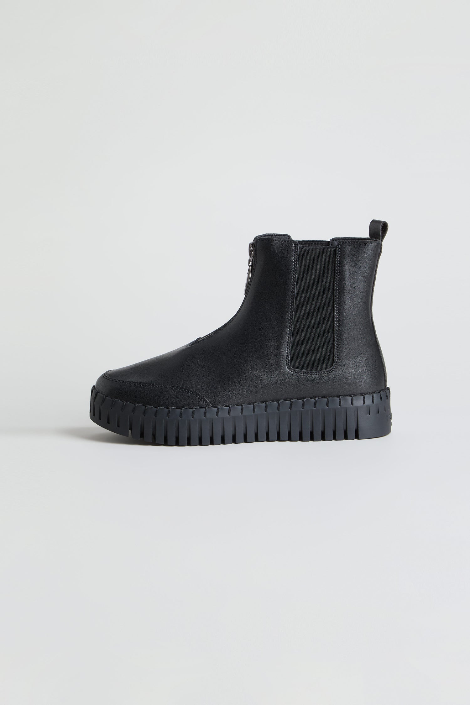The Tulip Zip Chelsea Boots, crafted from black recycled microfibre with an elastic side panel, side zipper, pull tab, and chunky treaded sole, are displayed on a plain light background.