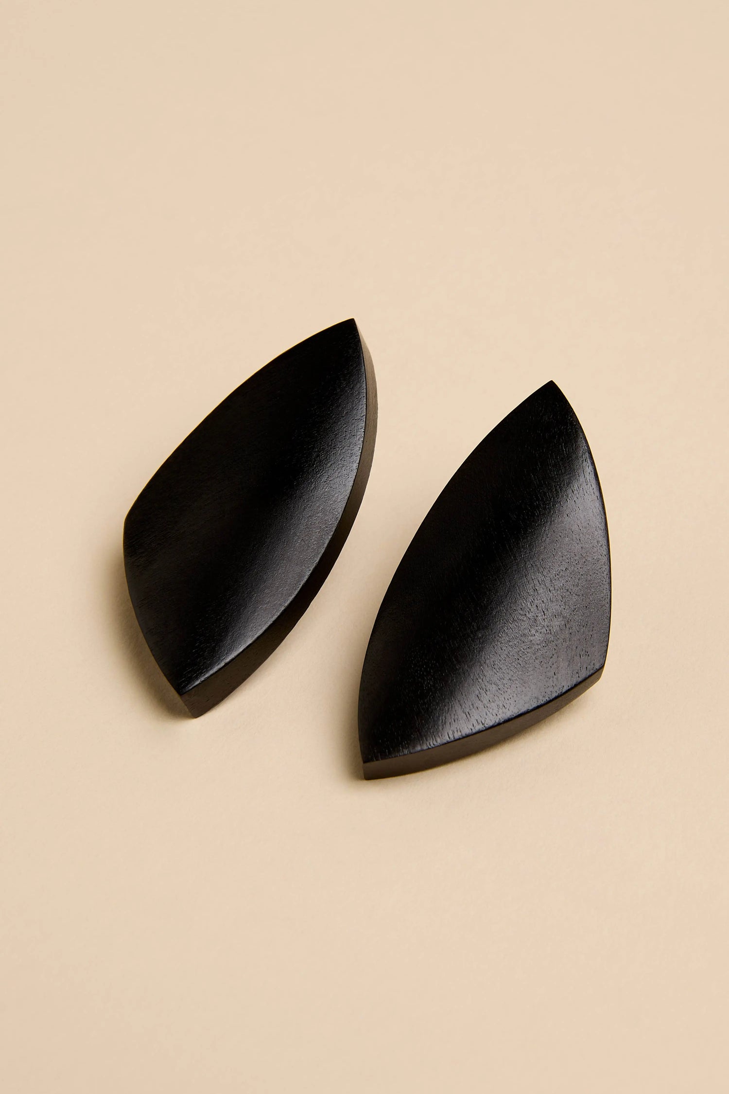 Sculptural Mango Black Wood Earrings featuring a pair of abstract, sculptural black wooden earrings with curved, geometric shapes.