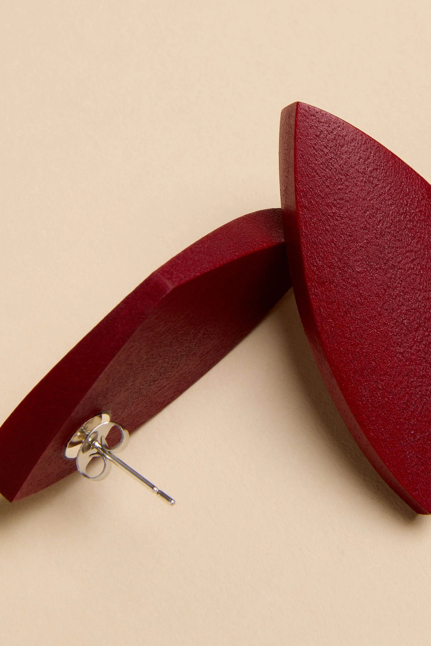 Sculptural Mango Red Wood Earrings featuring two dark red, sculptural wood studs with silver-toned posts.