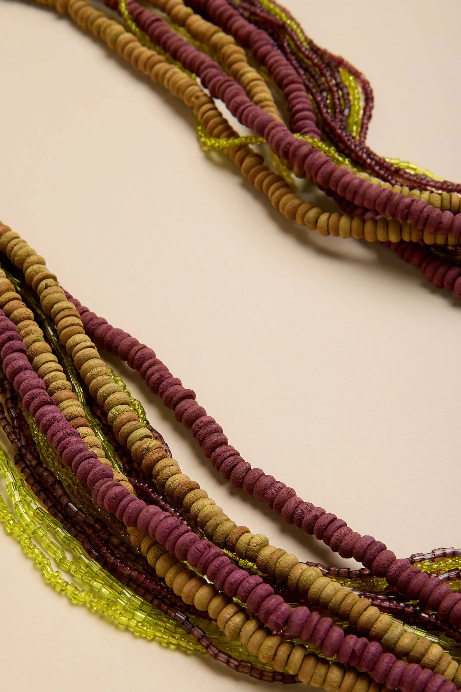 Mango Wood & Bead Waterfall Necklace featuring multi-strand maroon, tan, and translucent lime green beads.
