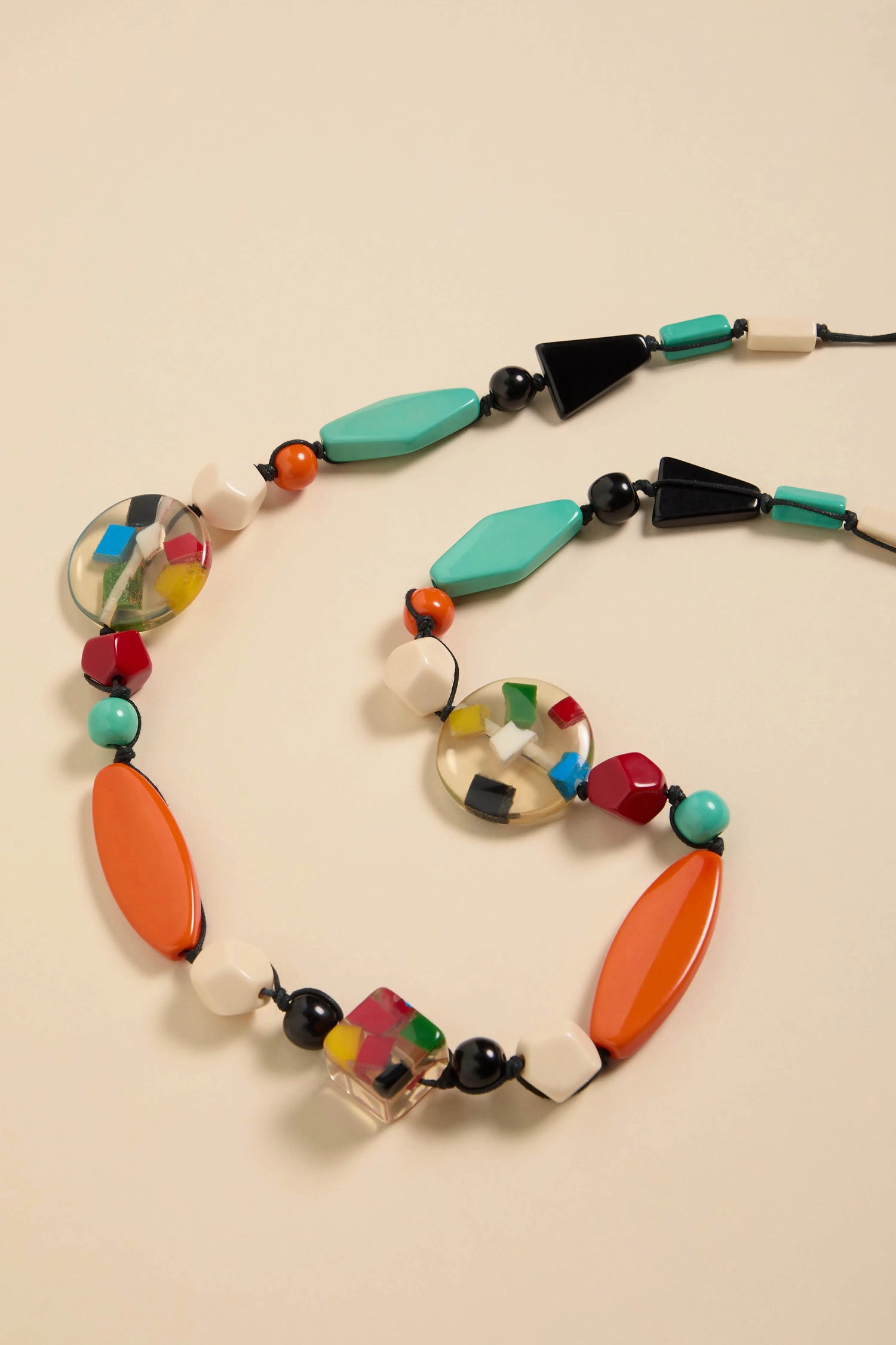 Colour Pop Resin Geometric Necklace featuring geometric resin beads in various colors, shapes, and clear segments strung on a black cord.
