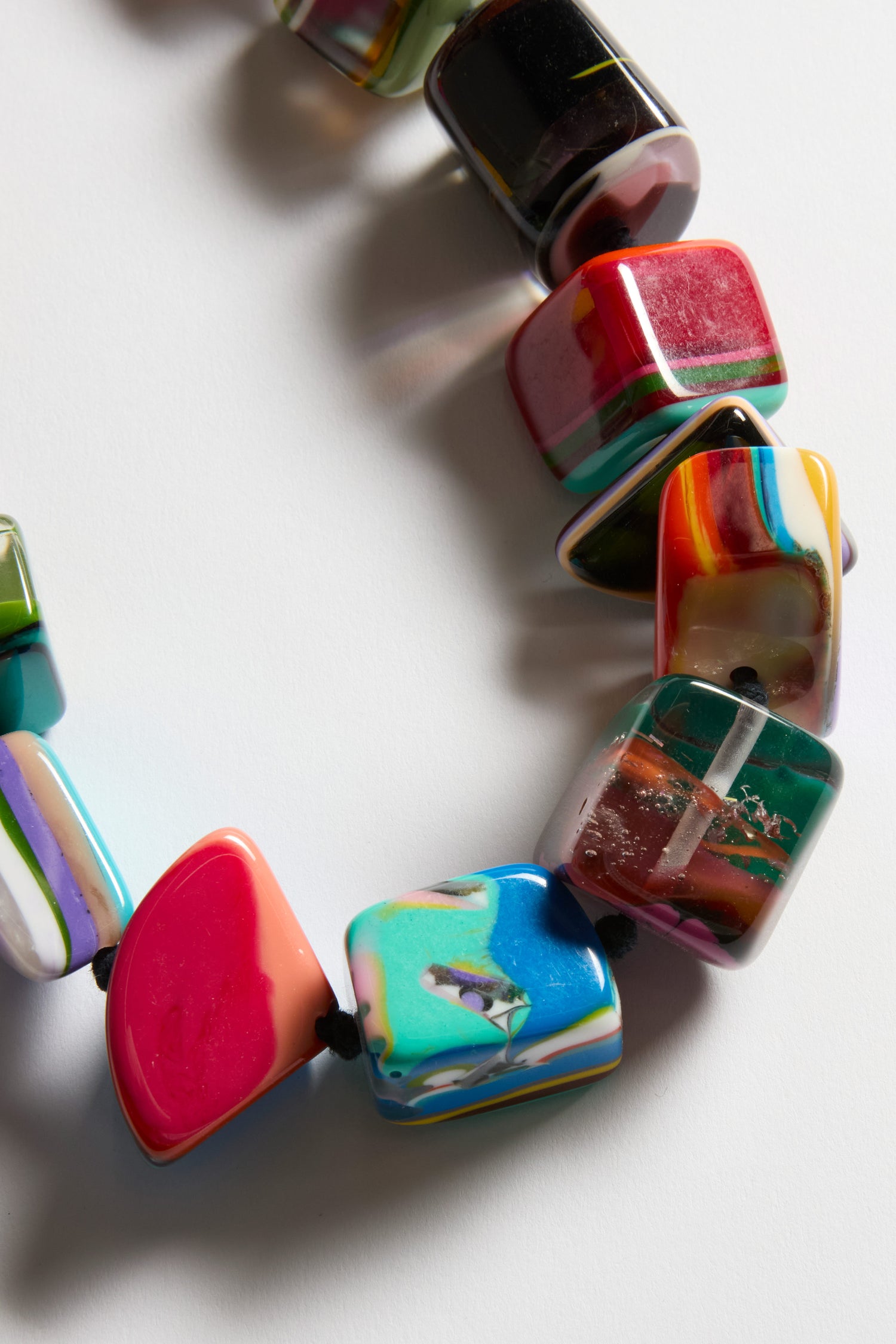 Close-up of the Kandinsky Pop Art Pebble Necklace featuring large, colorful, rectangular and irregularly shaped beads with various patterns, displayed on a white background.