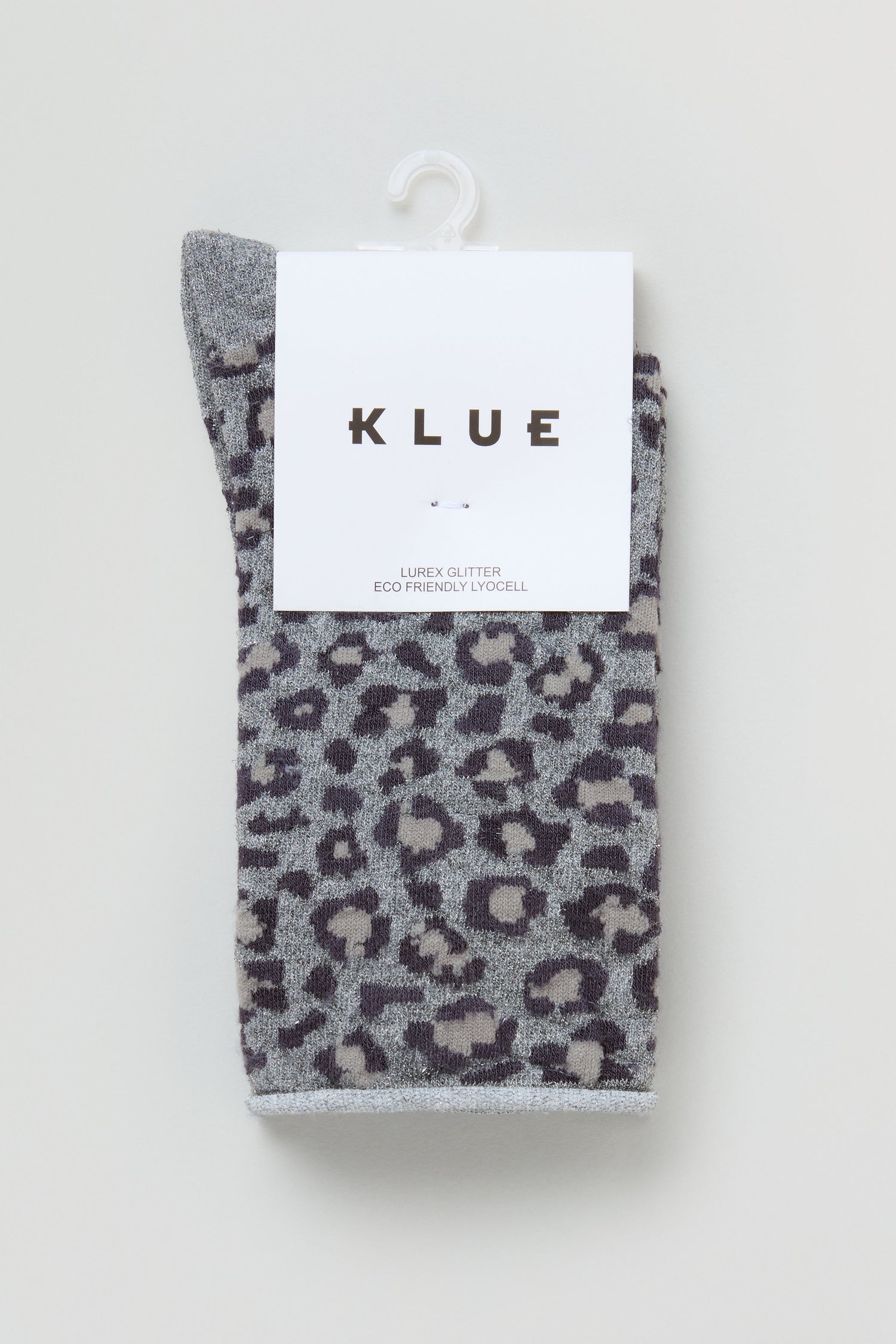 A pair of Bamboo Leopard Print Socks in grey with a black and beige pattern, folded and packaged with a white "KLUE" label, hanging on a white hook.