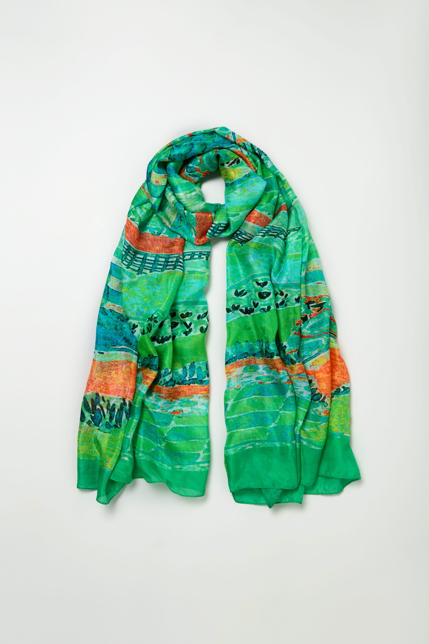 Meadow Silk Scarf in green with an orange and turquoise abstract print, shown loosely folded and laid flat on a plain light background.