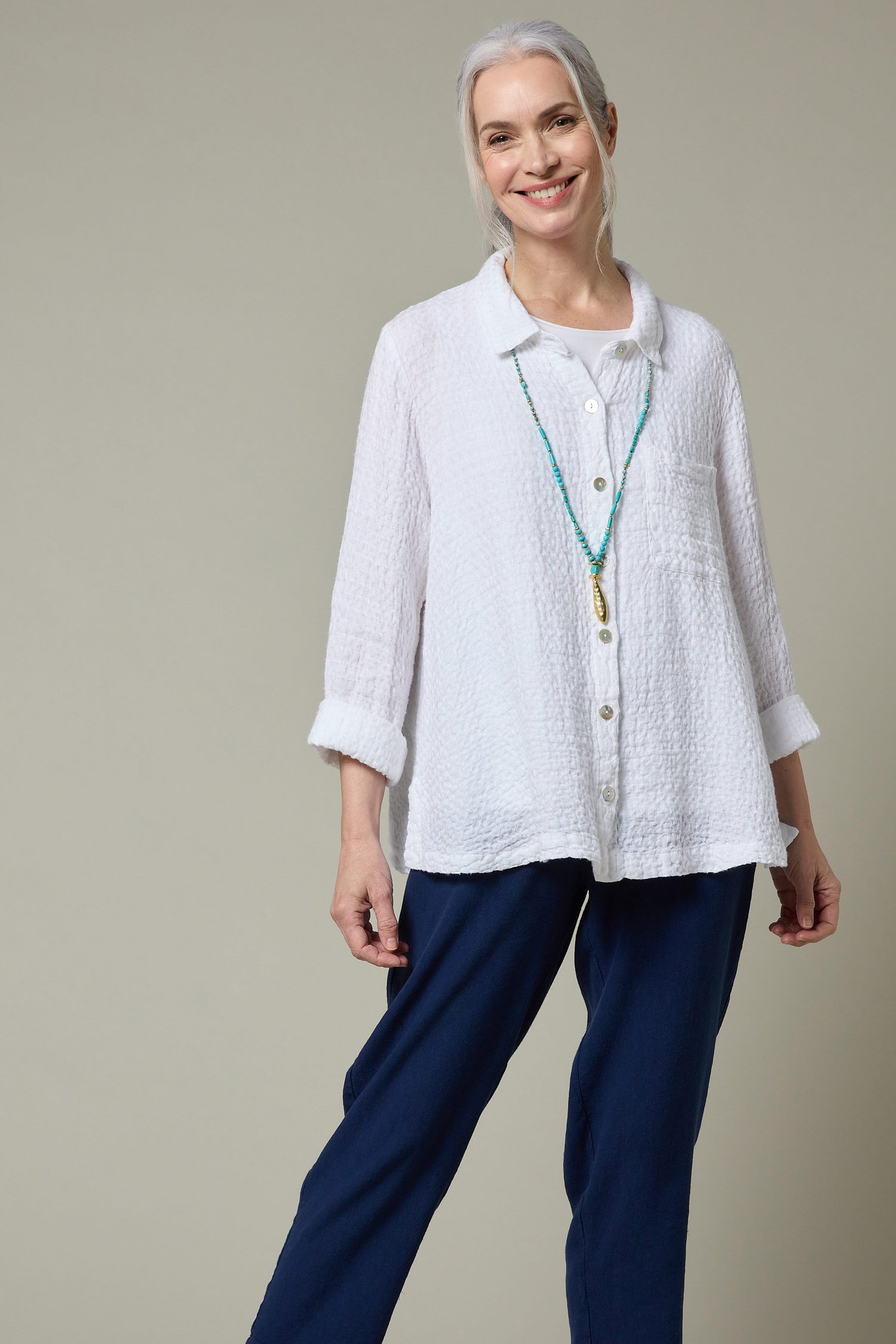 A woman wearing a white shirt and Twisted Linen Slim Trousers.