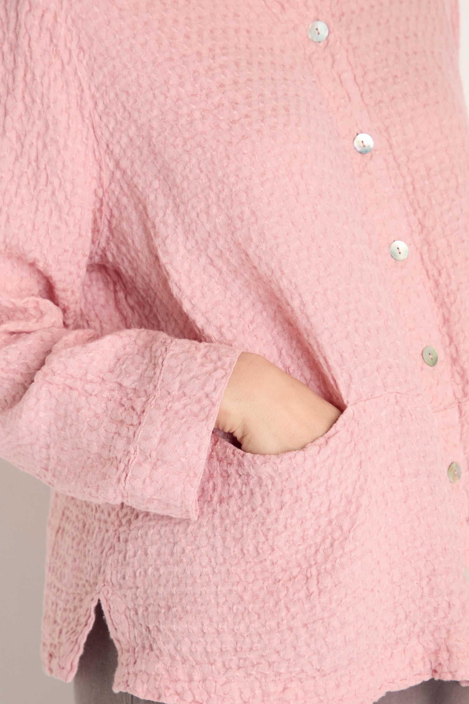 Person wearing the Waffle Linen Pocket Shirt in textured pink, styled with relaxed layering and one hand in the pocket.