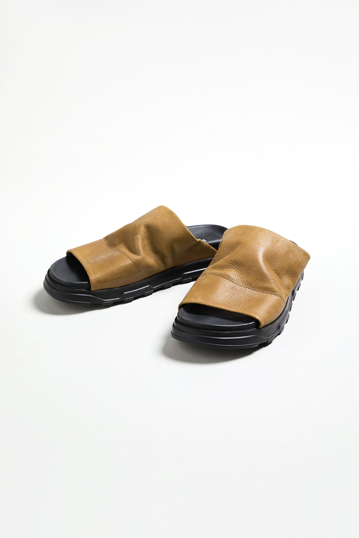 A pair of Crushed Leather Sliders with brown leather and black soles by Lofina, made in Italy, displayed on a plain white background.