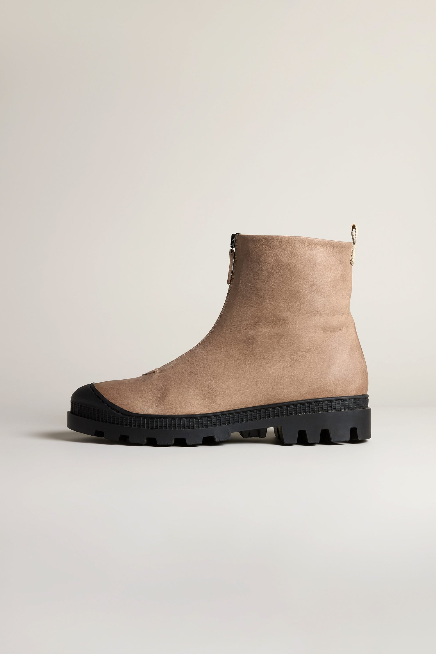 The Biscotti Zip Front Leather Boots feature beige leather, a front zipper, black rubber sole with lug tread, and are photographed on a light neutral background.