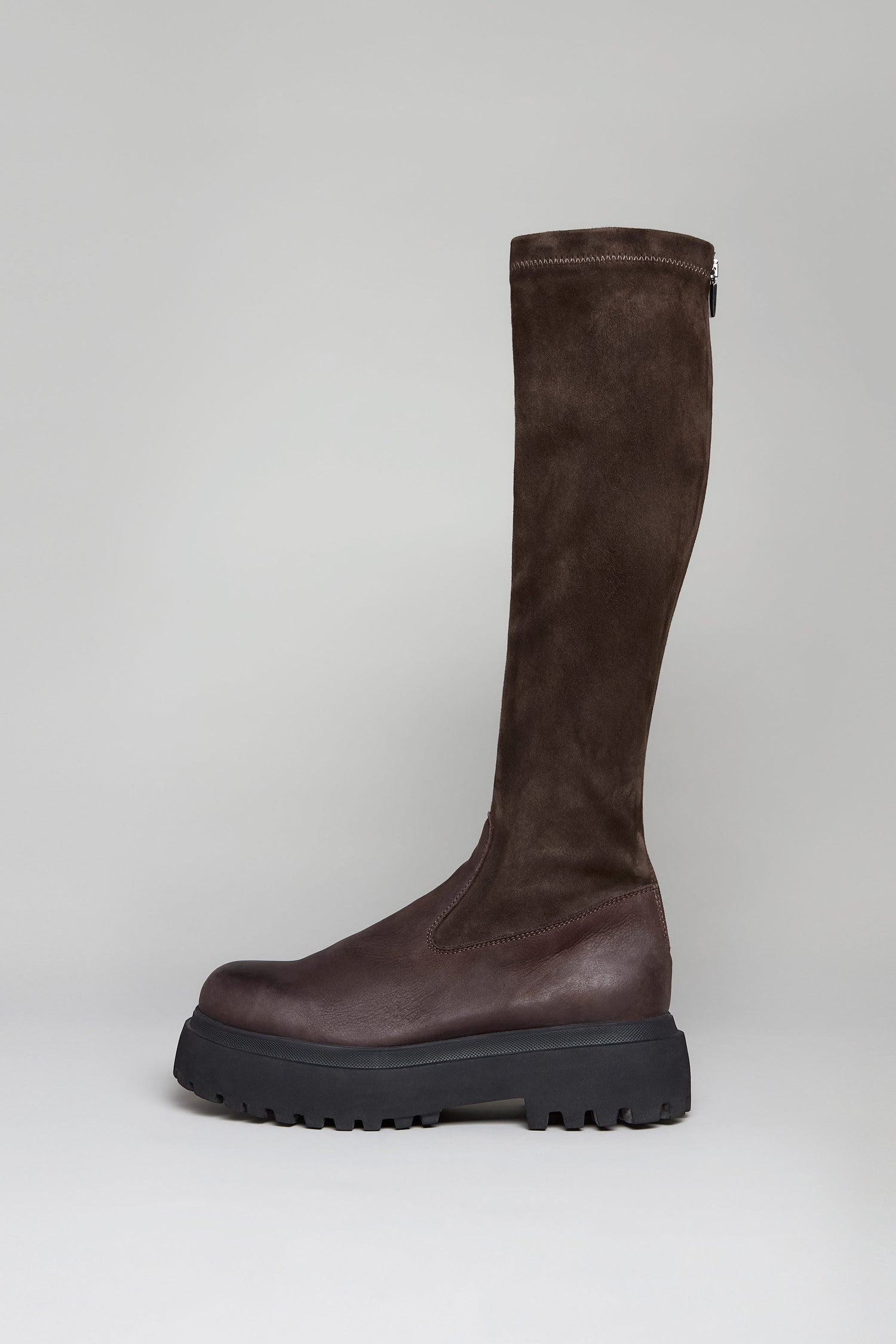The Chocolate Long Stretch High Knee Suede Boot is a single dark brown knee-high with a chunky black platform sole, combining leather and chocolate suede textures, shown against a plain light background.