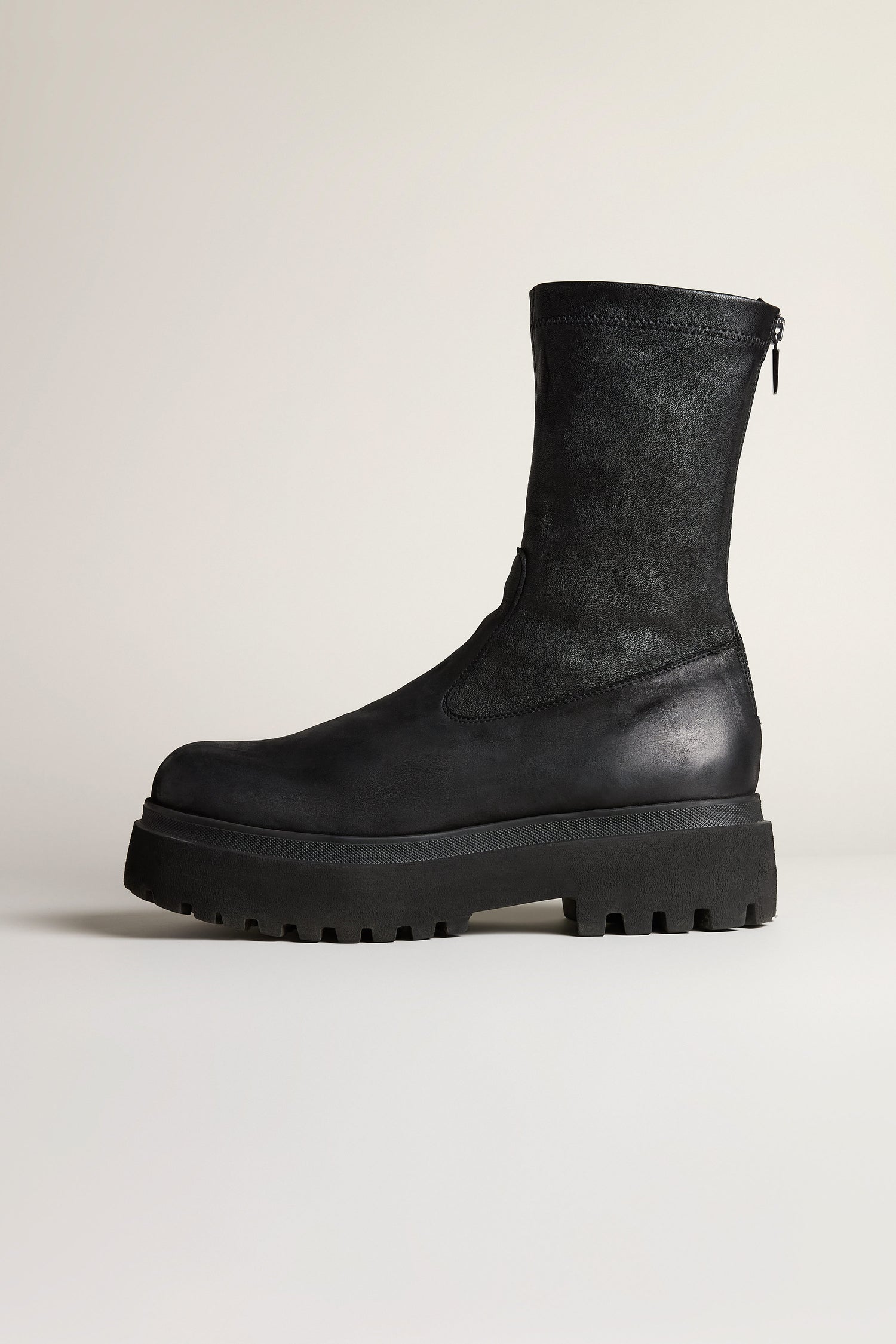 The Short Stretch Leather Black Boots by Lofina are mid-calf, feature a chunky lug sole, and are shown in profile against a plain light background.
