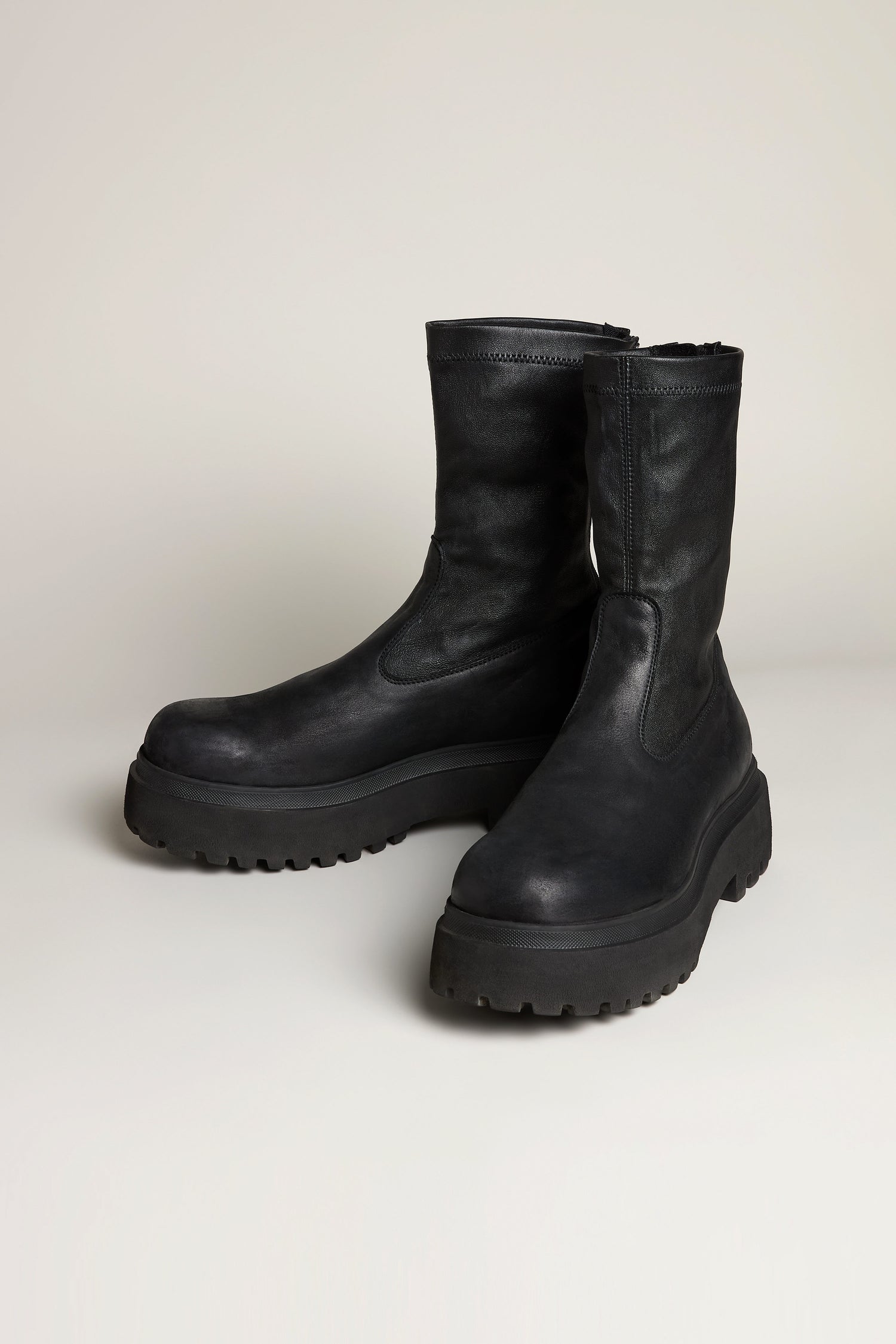 Short Stretch Leather Black Boots featuring thick, rugged platform soles are crafted from stretch leather and showcased on a neutral background.