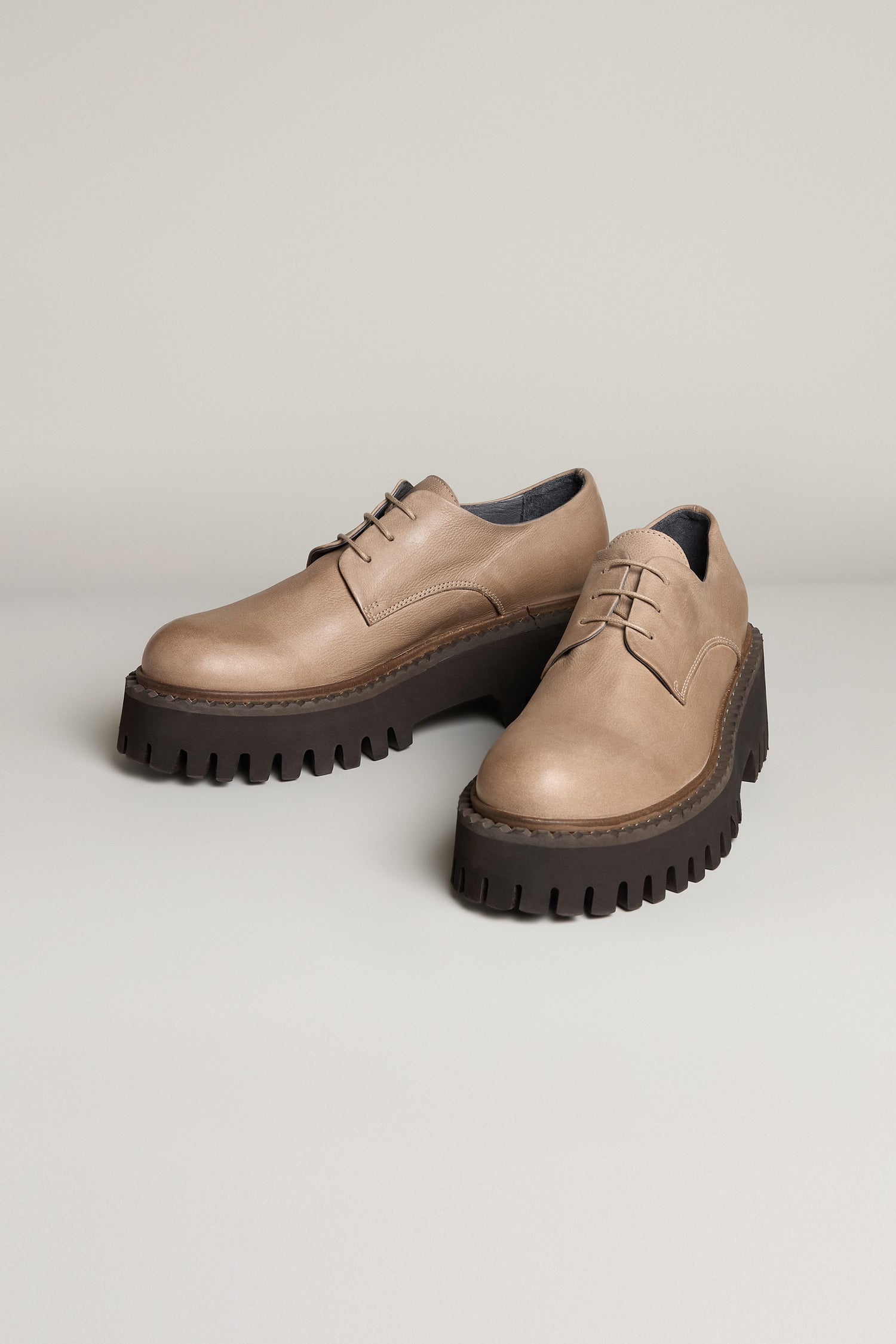 Two Tone Lace Up Leather Brogues in beige leather with contemporary black soles, styled with laces and showcased on a neutral background.