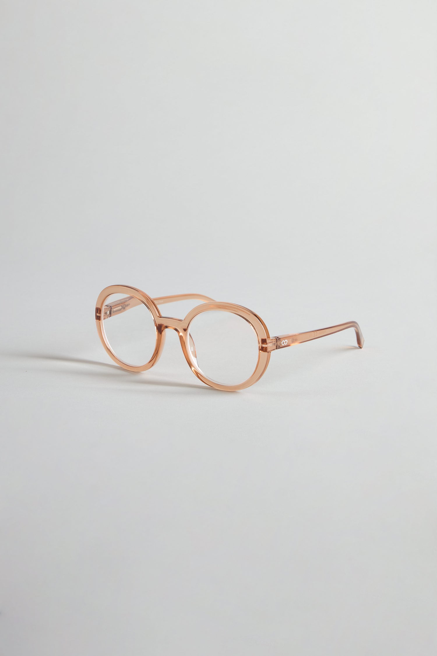 Crystal Champagne Round Reading Glasses with premium optician-quality lenses in light pink are displayed on a simple, pale background.