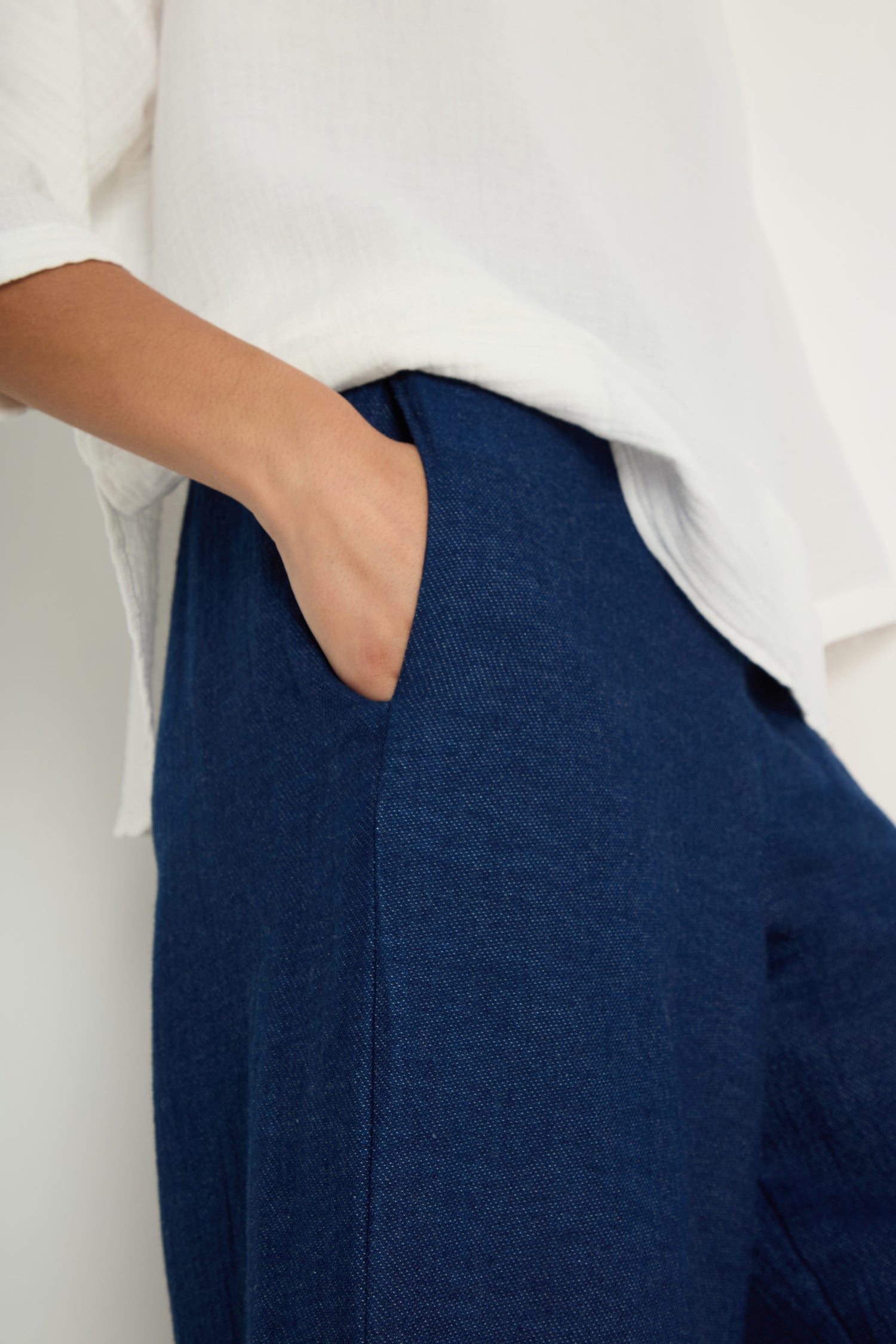 Person wearing a white long-sleeve shirt and Wide Leg Slit Trousers, with one hand in the pants pocket.