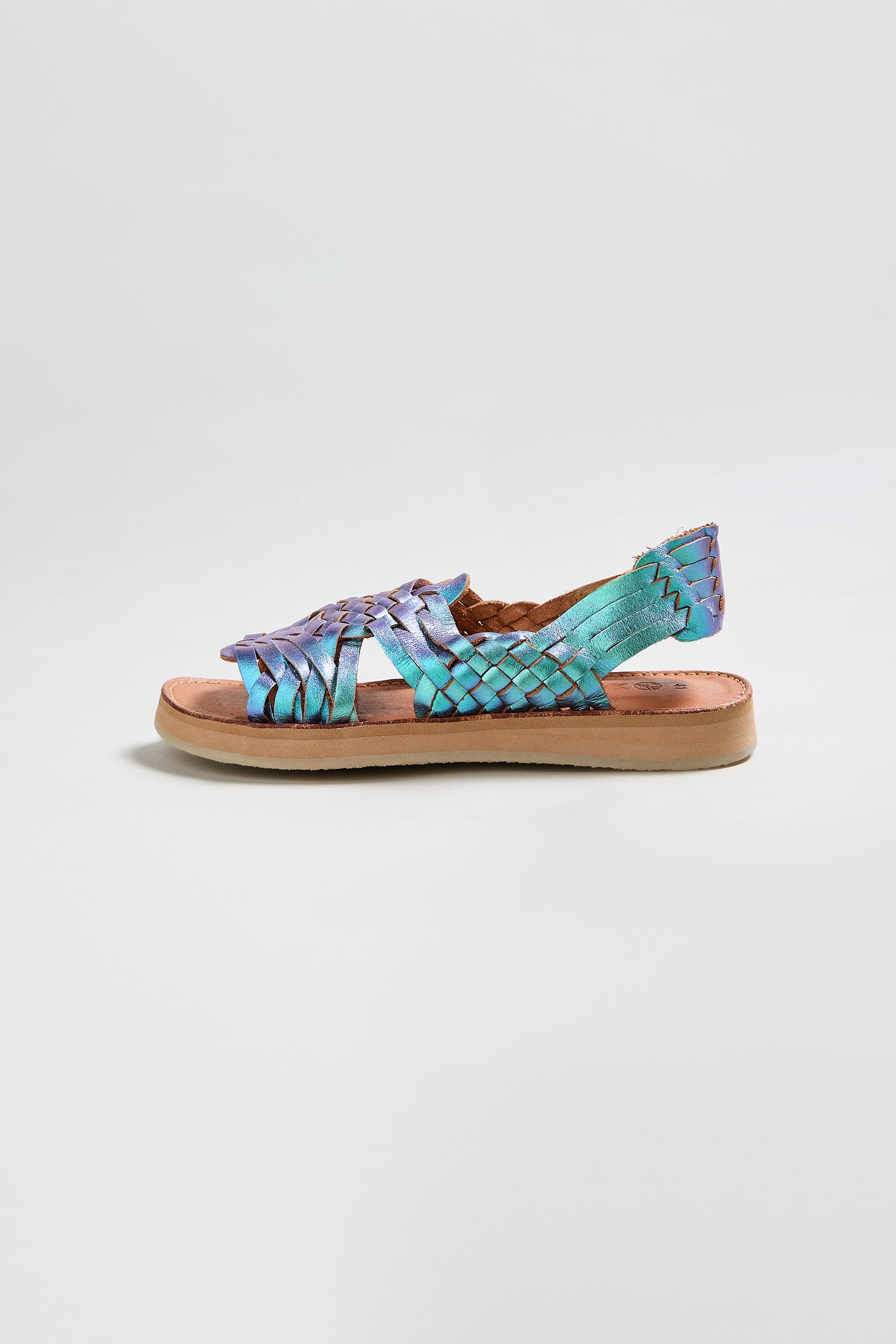 The Frida Mermaid Leather Sandals are handcrafted in Mexico with a woven iridescent blue and purple leather upper, tan sole, and open toe, shown on a plain white background.