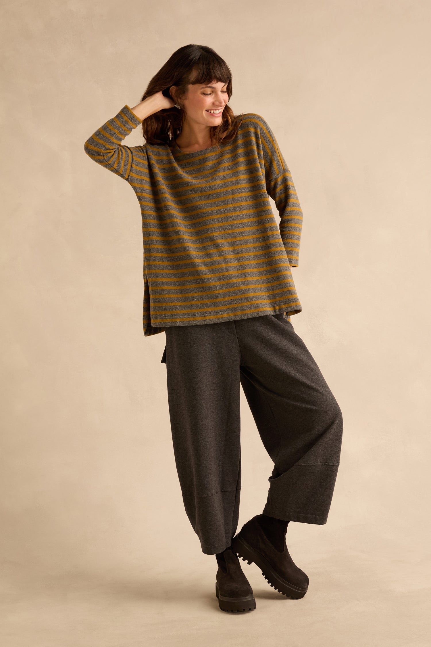 A person wears a Scoop Neck Wide Stripe Jersey Top in a relaxed shape, paired with loose-fitting dark trousers and platform boots.