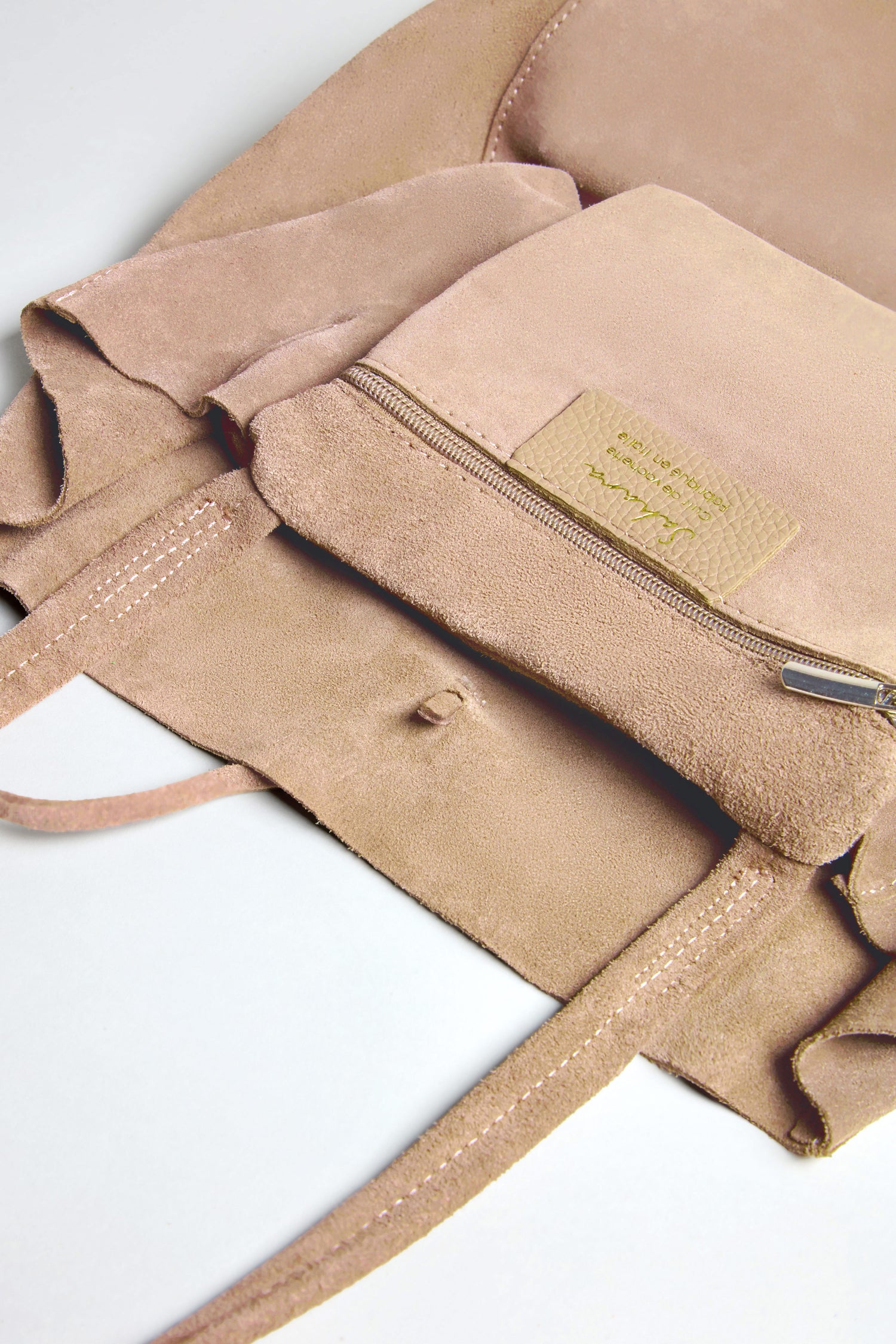 Close-up of the Soft Suede Sand Tote Bag's open, spacious interior pocket featuring a zipper and fabric label, emphasizing its minimalist design.