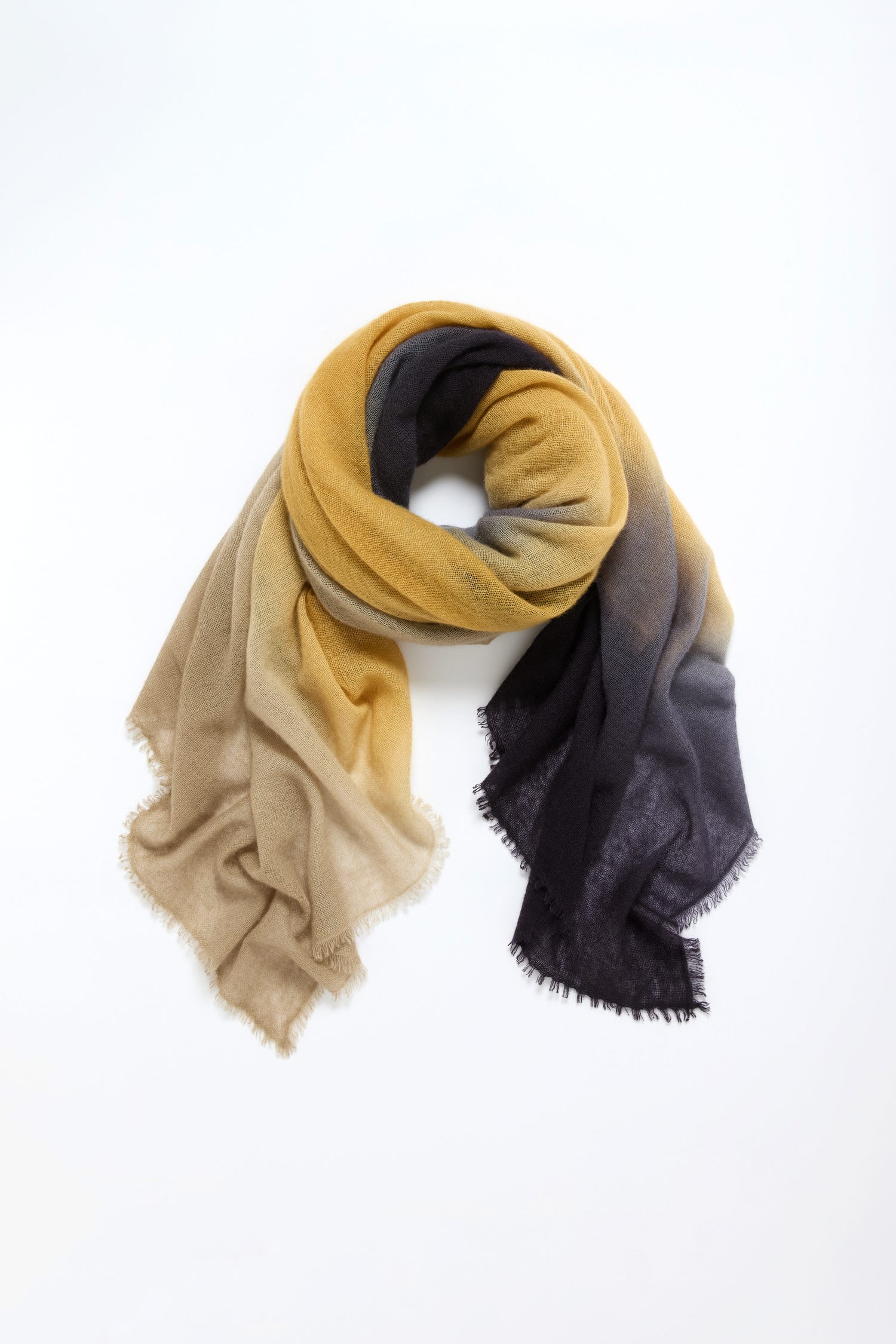 The Soft Colourblend Cashmere Shawl features an ombré gradient of yellow, beige, and dark gray, displayed in a circular arrangement on a white background.