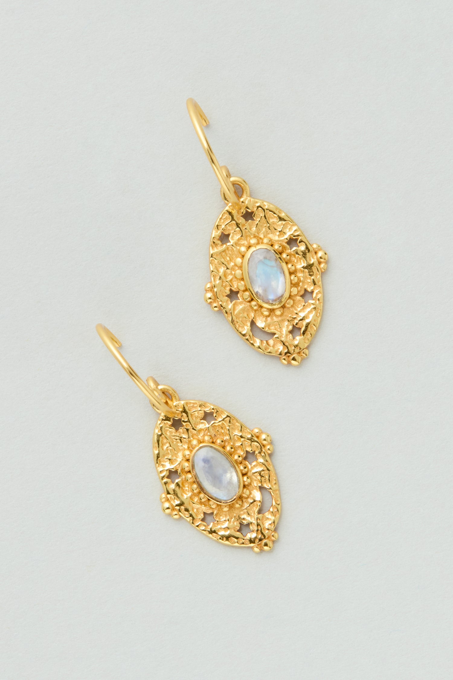 Gold Plated White Moonstone Orion Earrings featuring an intricate filigree design and a central oval white gemstone, style MJU10965GB1, displayed on a light background.