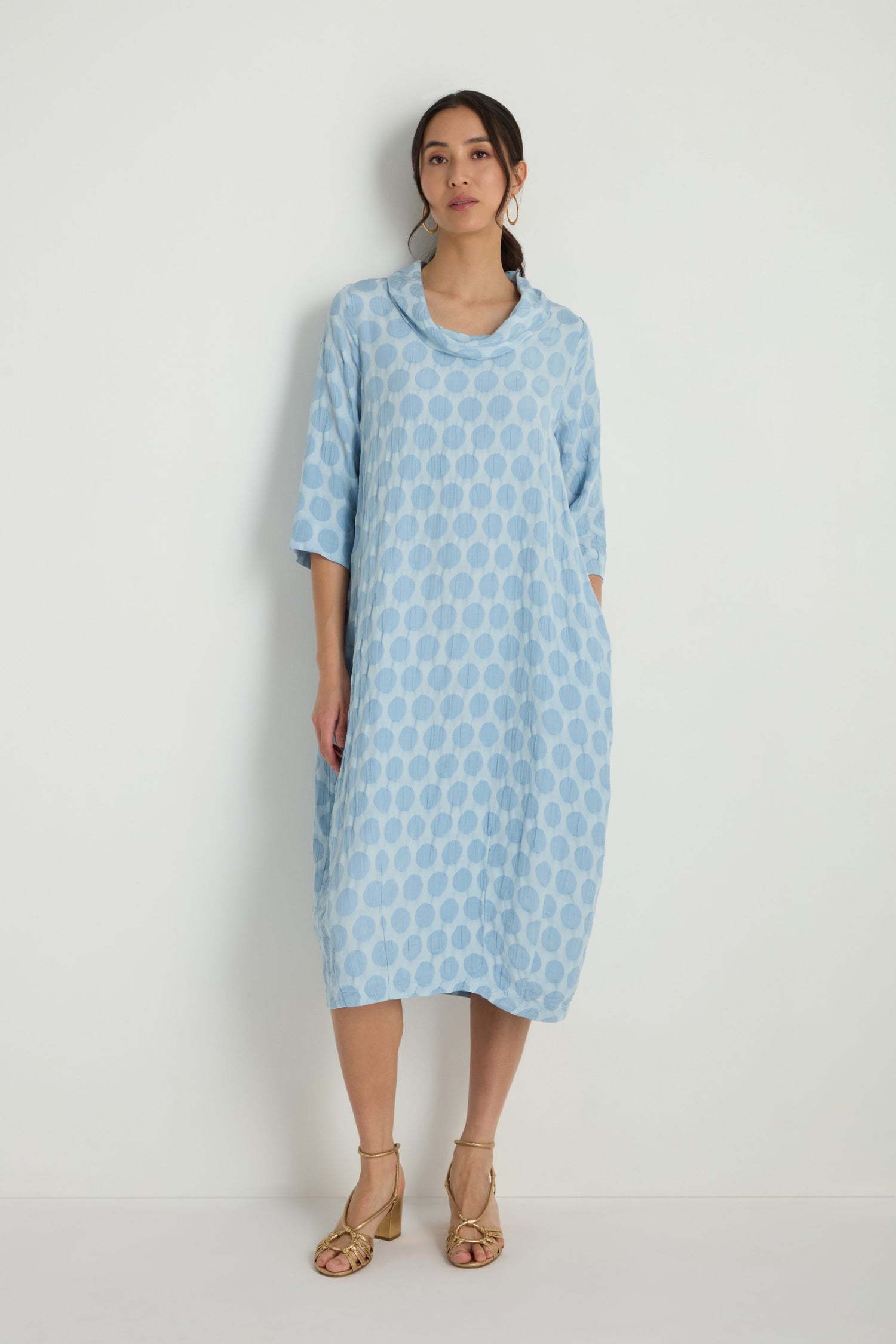 A woman wears the Spot Textured Jacquard Bubble Dress in light blue with three-quarter sleeves and lace-up wedge sandals, standing against a plain white background.