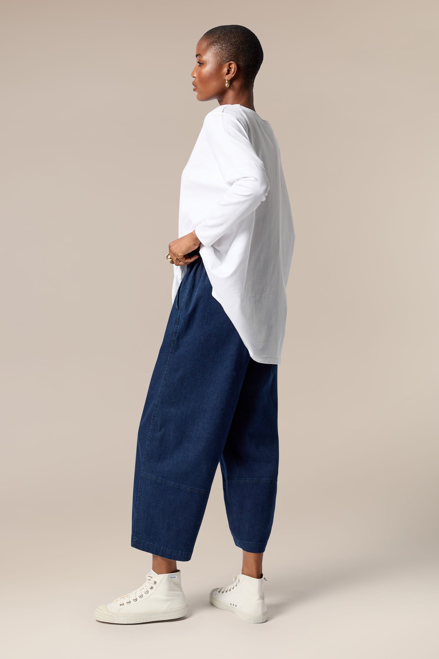 A woman wearing a white t-shirt and indigo Stretch Denim Bubble Trouser.
