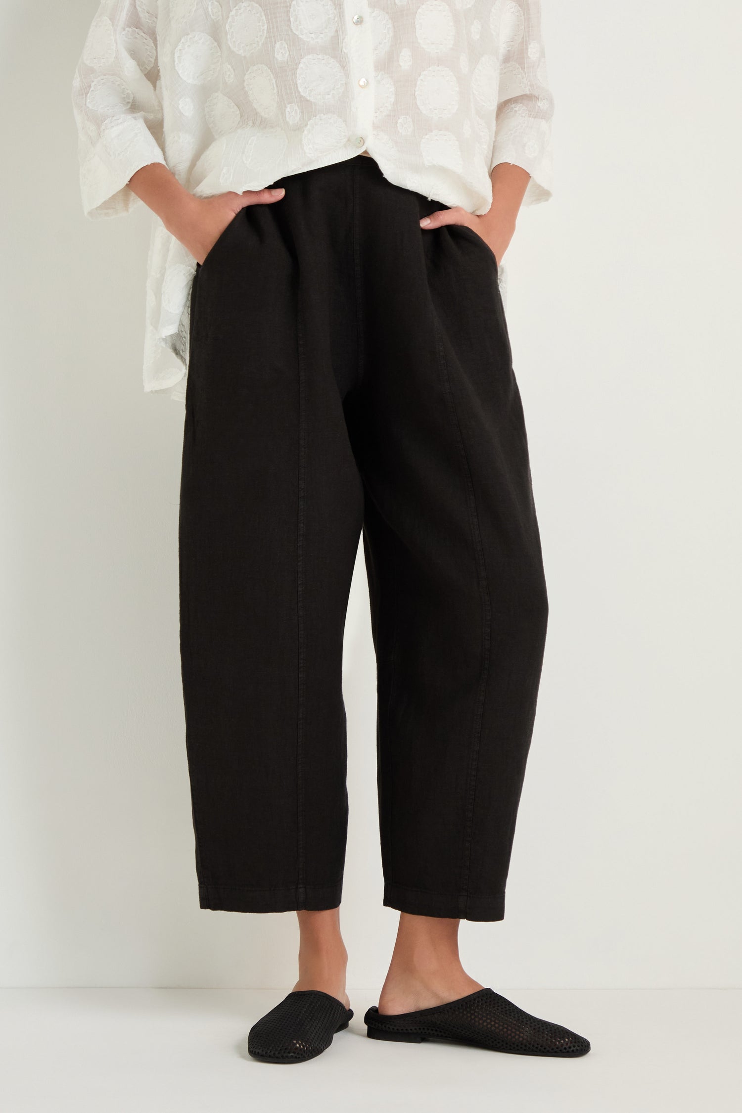 A person wearing the Linen Seam Detail Black Bubble Trouser, a white patterned button-up shirt, and black slip-on shoes stands against a plain background.