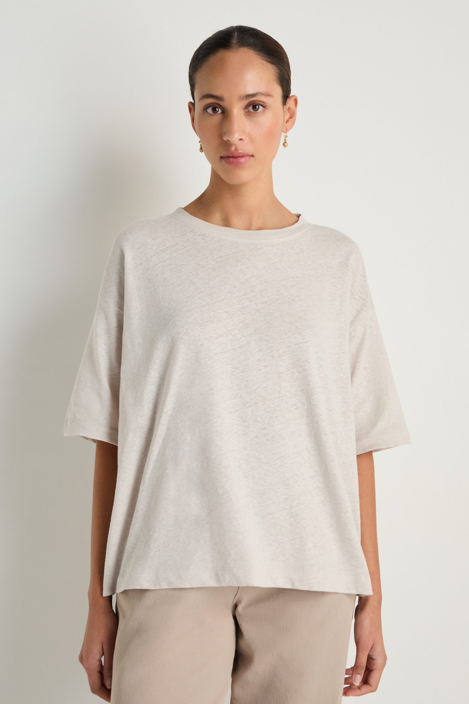 A woman stands against a plain white background, wearing the Linen Cotton Jersey Top in light beige and tan pants—a relaxed fit, breathable women’s top for effortless style.