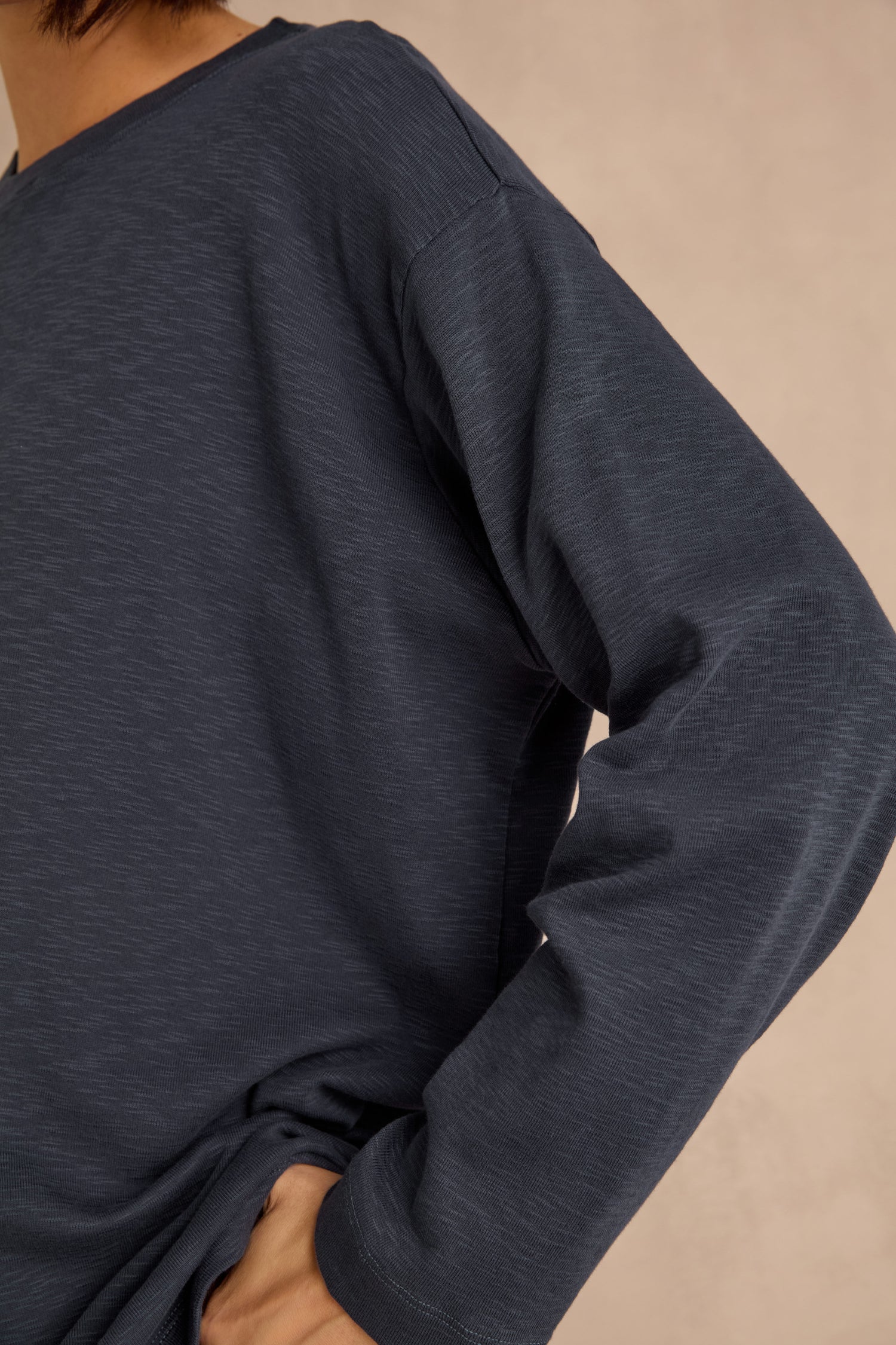 A person wearing the Navy Boxy Cotton Jersey T Shirt with a loose, longline fit, shown from neck to waist with one hand resting on their hip against a neutral background.