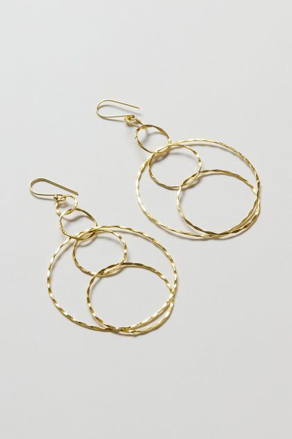 Dharma Earrings from the Nataraj Collection, featuring three interlocking textured gold-finished hoops, displayed on a light gray background.