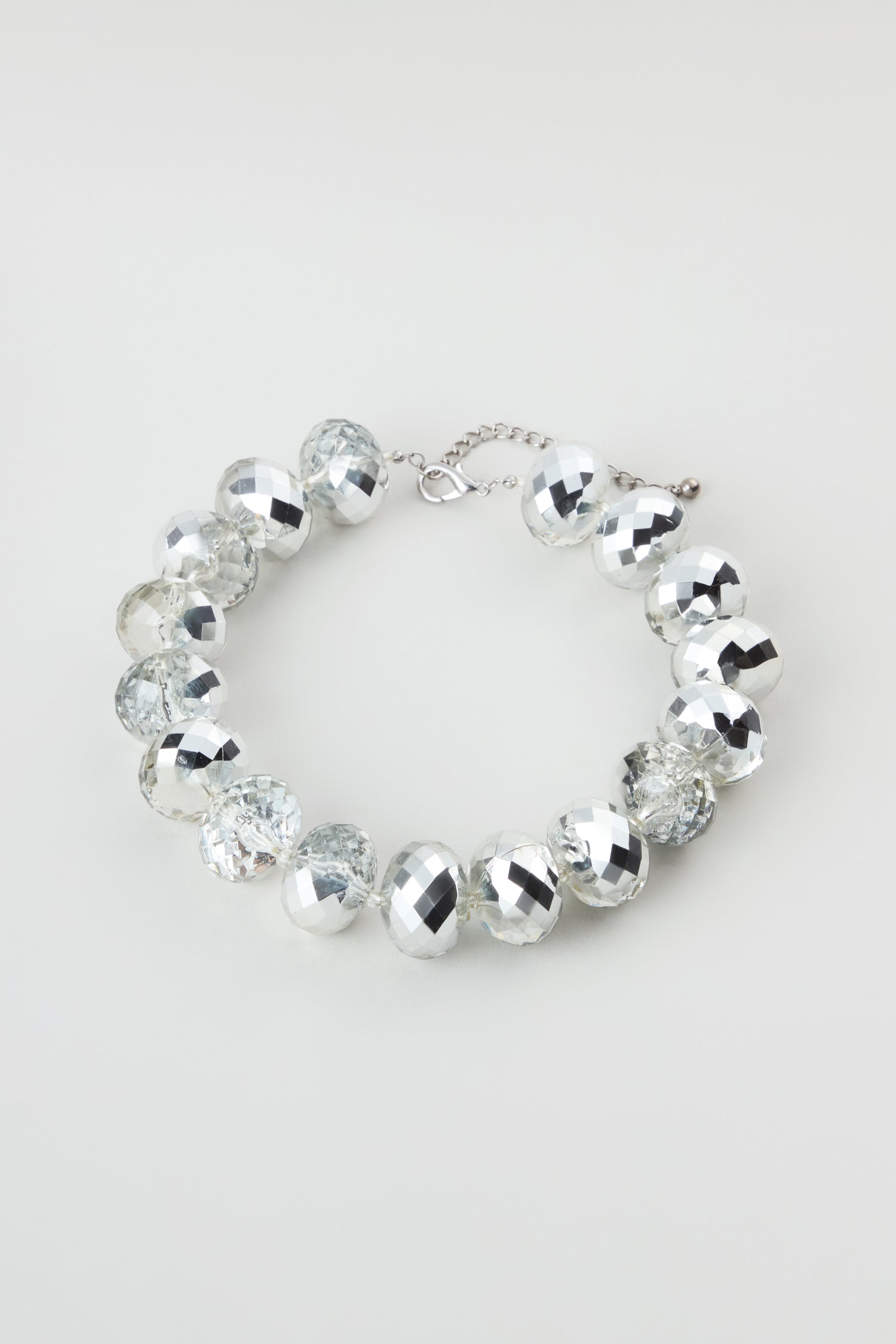 The Silver Disco Necklace shimmers with alternating clear and silver faceted round beads and an adjustable chain clasp, beautifully displayed on a plain light background.