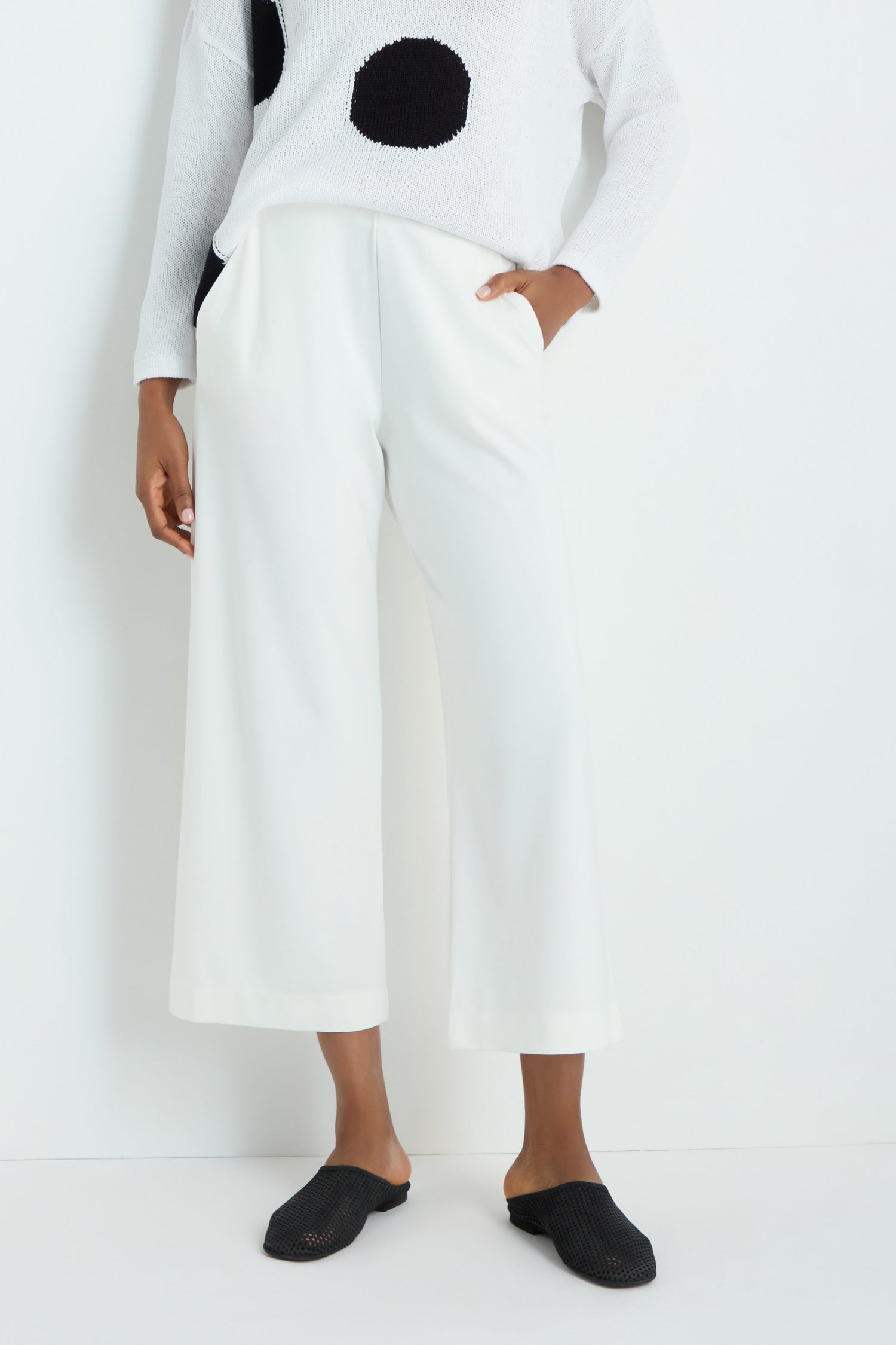 Person wears Wide Leg Pocket Trousers with an elasticated waist and white sneakers, standing against a plain white background with hands in pockets.