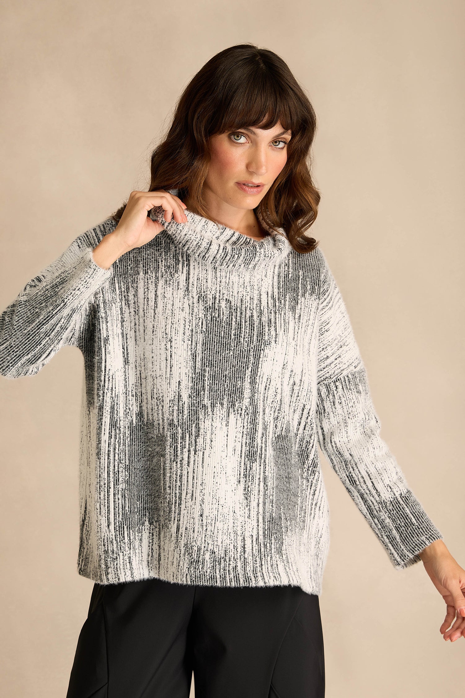 A person stands against a plain beige background wearing the Greyscale Textured Jersey Top and black pants.