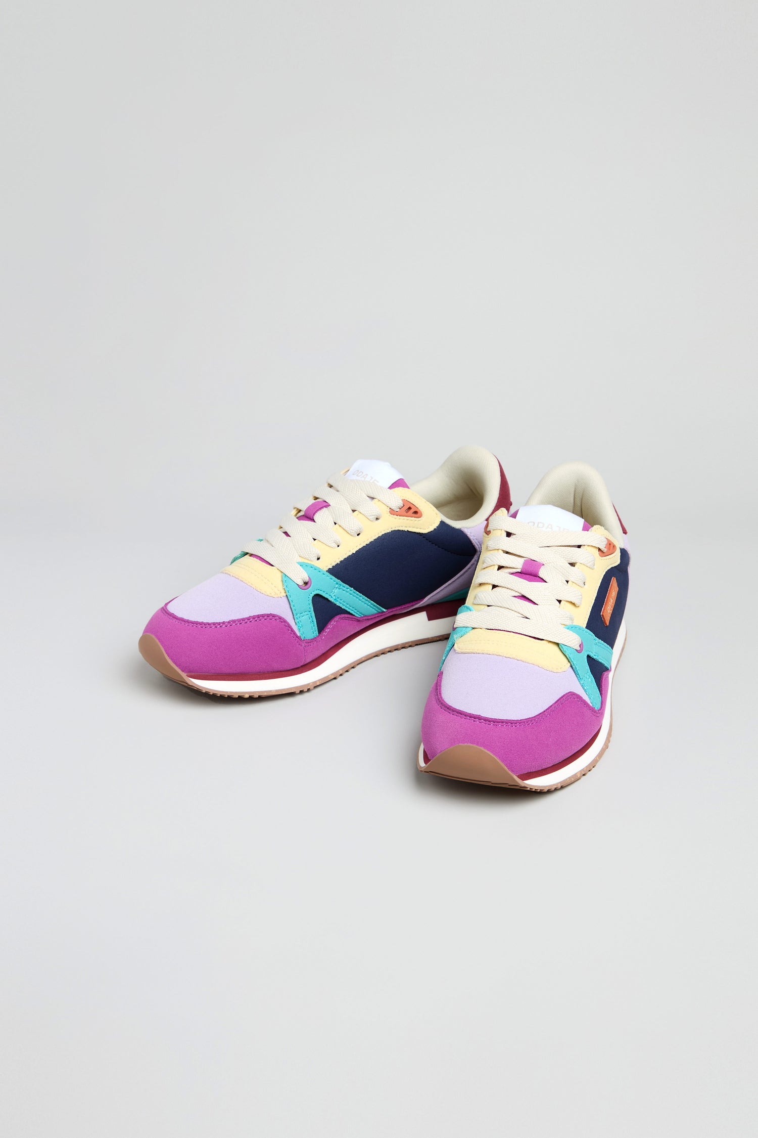 The Colour Pop Andree Trainers are vibrant vegan shoes featuring playful pink, purple, blue, yellow, and white color blocking displayed on a clean white surface.