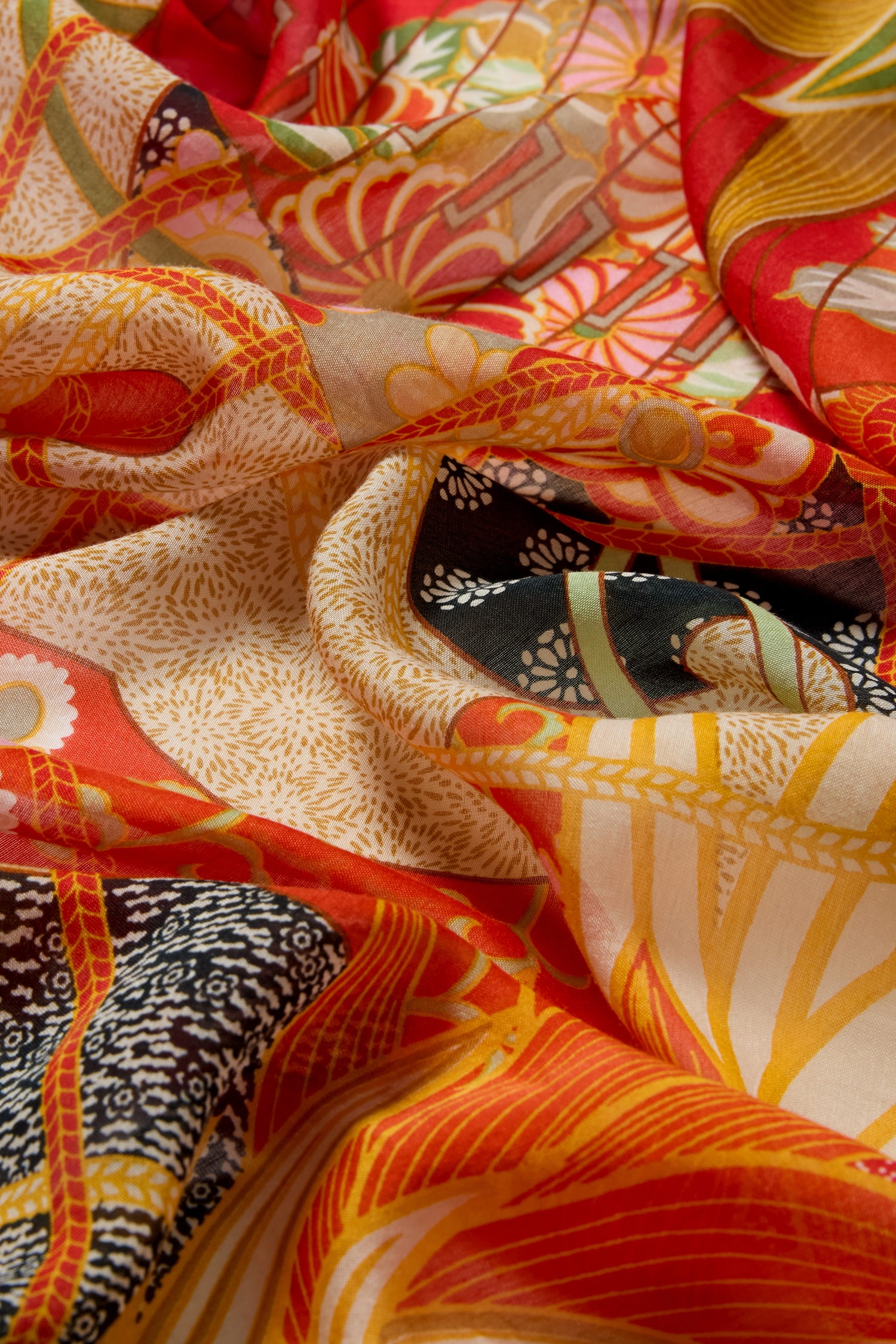 Close-up of vibrant fabric with red, yellow, black, and beige fans print featuring bold botanical and geometric patterns—perfect for a striking Fans Print Scarf.