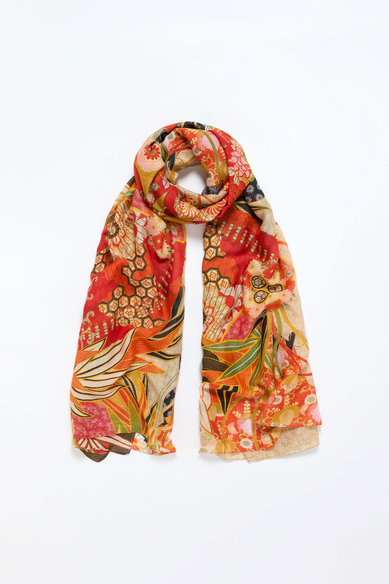 The Fans Print Scarf showcases bold botanical and geometric patterns in red, orange, yellow, and green on a light background, displayed flat with the ends draped down.