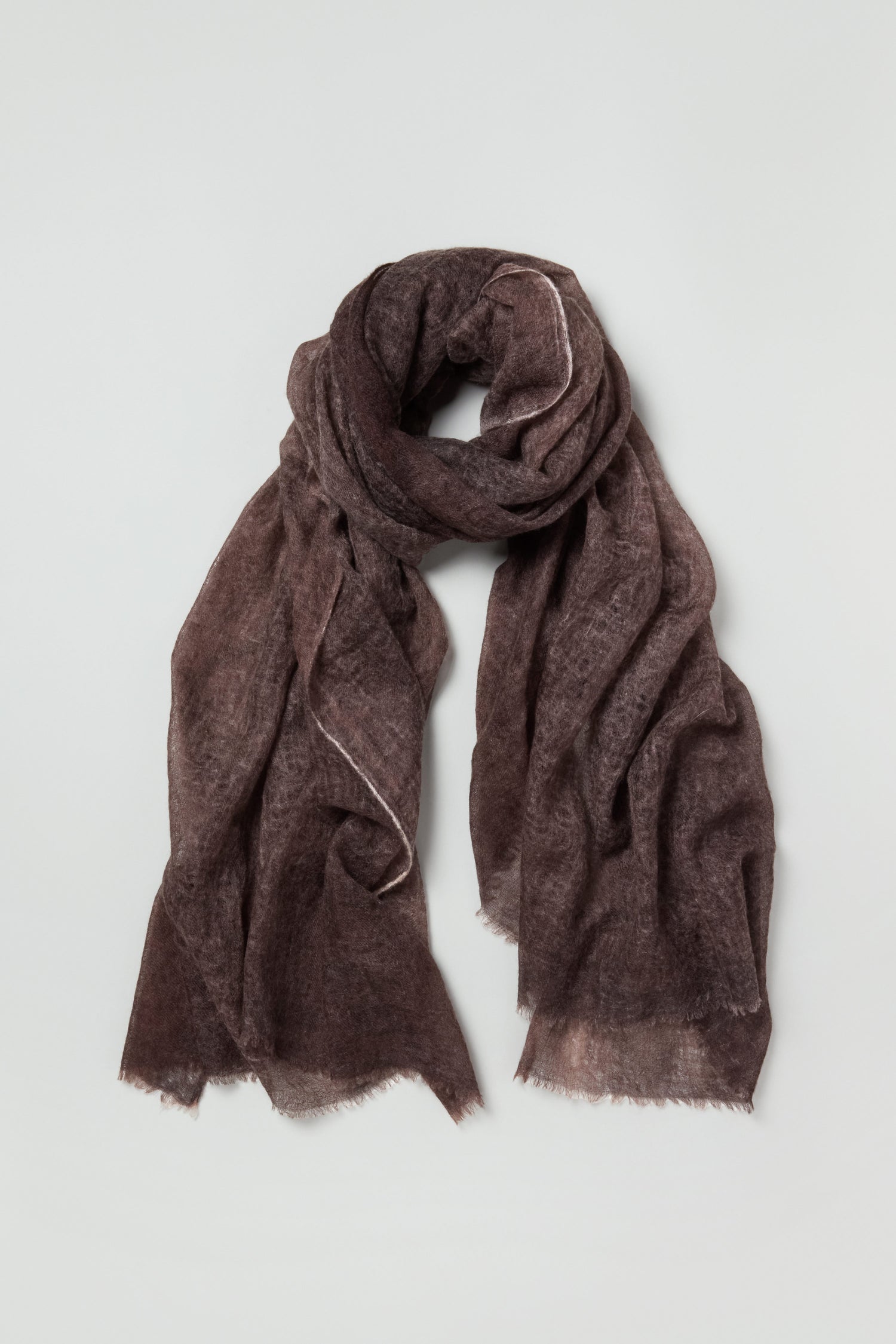 The Soft Espresso Cashmere Scarf features a rich brown hue and a softly textured finish, loosely folded on a plain light gray background—a luxurious accessory for any wardrobe.
