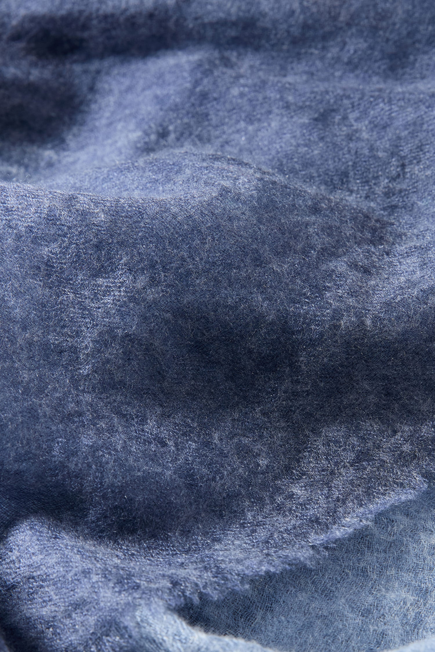 Close-up of the Night Sky Gradient Cashmere Scarf, featuring a soft blue textured surface with gentle folds and visible fibers, evoking a sense of luxury.