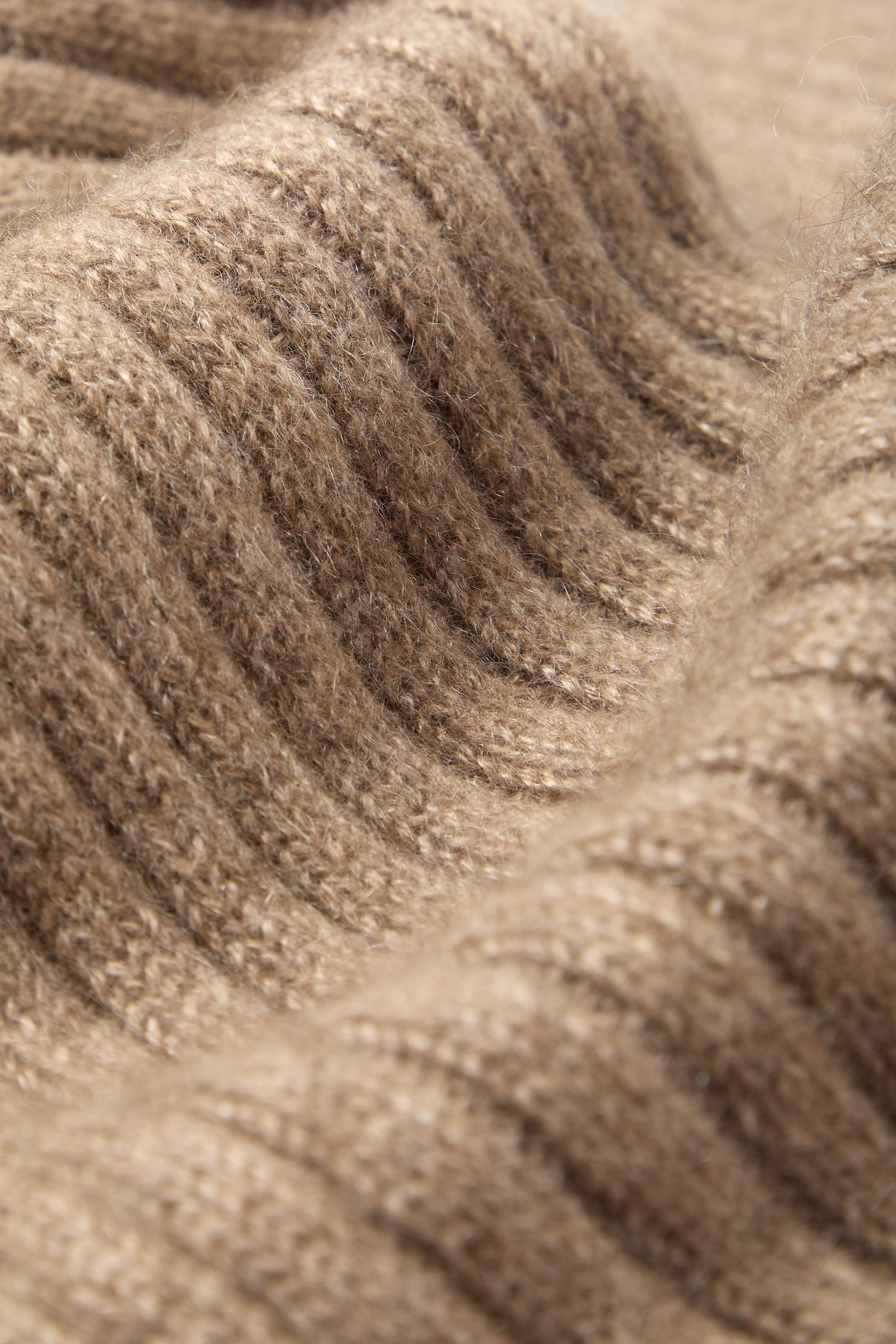 Close-up view of the Warm Sands Ribbed Cashmere Scarf, featuring a soft, textured ribbed brown knit—perfect for a cozy winter wardrobe or as a touch of luxury.