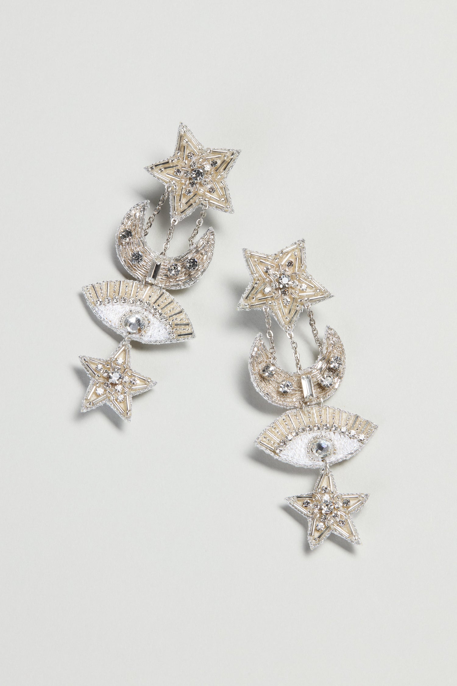 Hand Beaded Celestial Silver Earrings from Psquuare Fashion Jewellery, adorned with star, moon, and eye motifs plus rhinestones, shown on a light background.