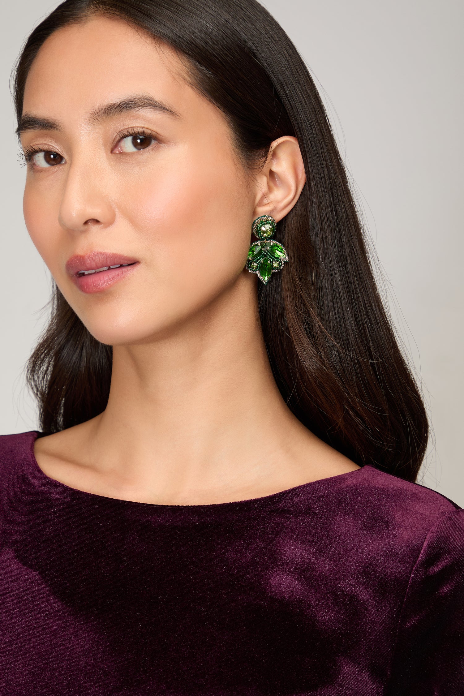 A woman in a purple dress completes her look with Hand Beaded Flower Earrings, adding a touch of artisan jewelry charm.