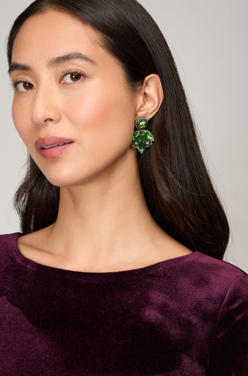 A woman in a purple dress completes her look with Hand Beaded Flower Earrings, adding a touch of artisan jewelry charm.