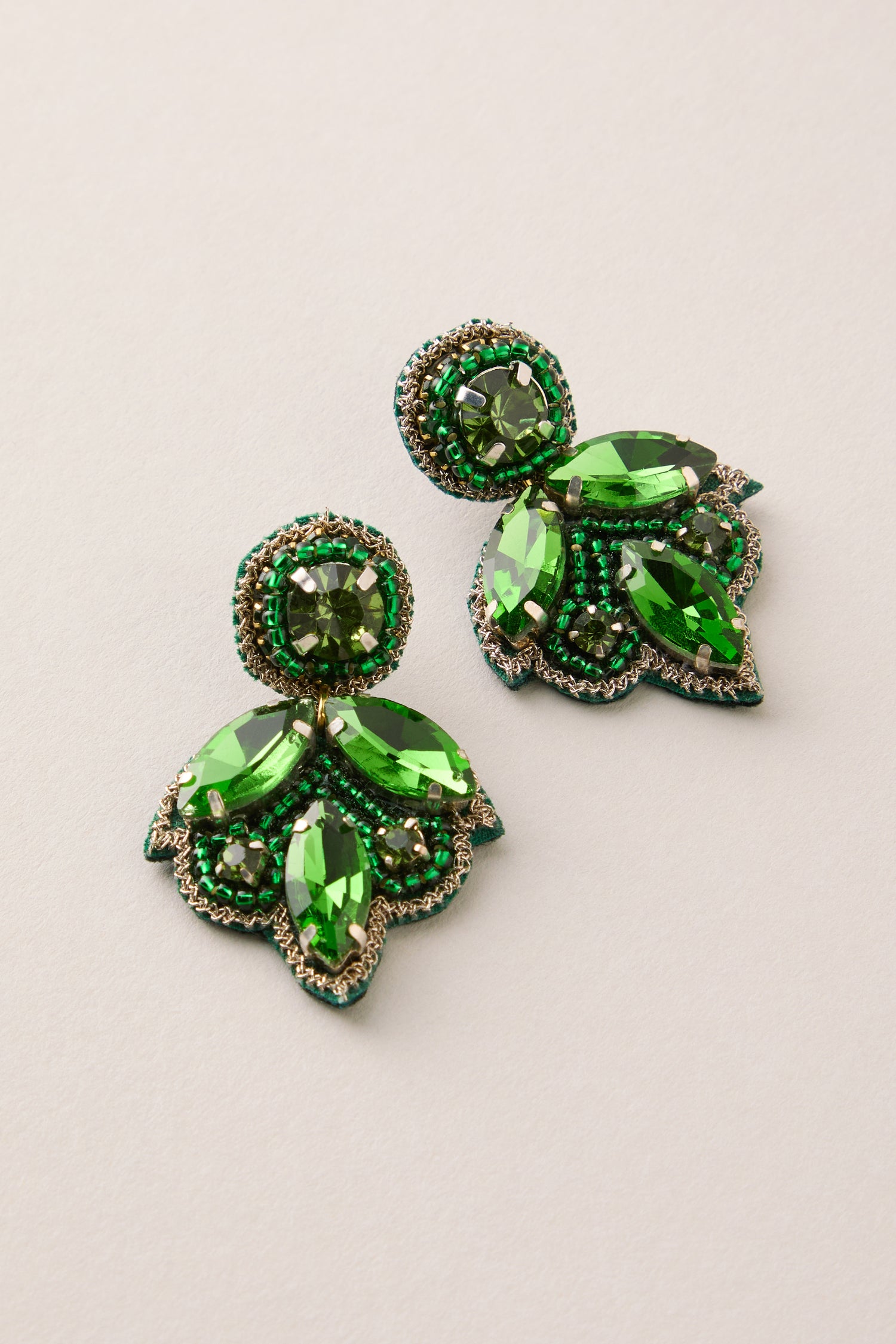 Hand Beaded Flower Earrings: Ornate, lightweight statement earrings featuring green gemstones and intricate beads, with round and teardrop stones in a floral design.